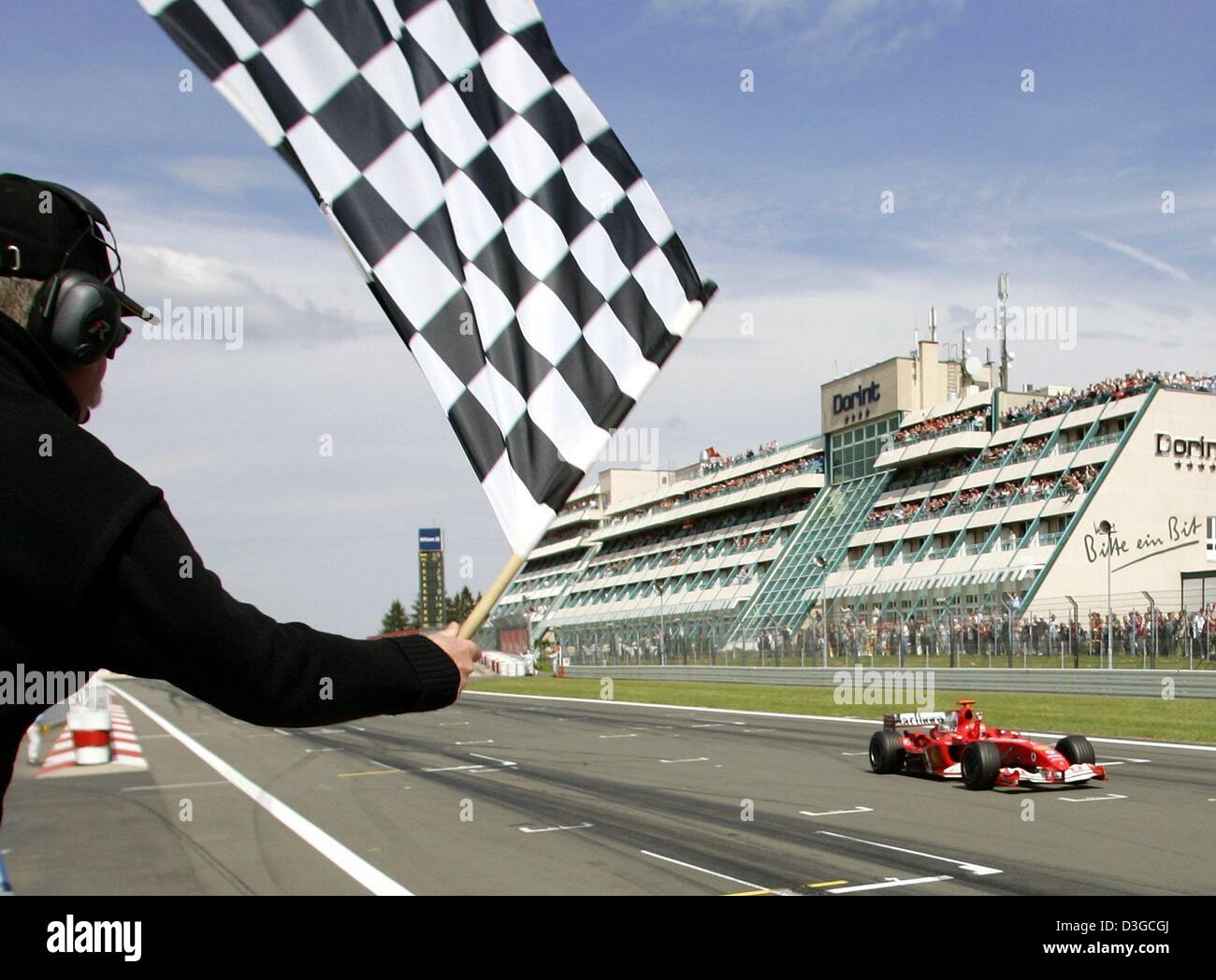 (Afp) - Le champion du monde de Formule 1 Michael Schumacher (Ferrari) voit le drapeau à damier au Grand Prix d'Europe sur le Nürburgring race track, 30 mai 2004. Pour la première fois dans l'histoire de la Formule 1, le championnat de F1 2005 devrait être décidé plus de 19 courses après l'instance dirigeante du sport automobile, la FIA, a révélé la prochaine saison calendrier provisoire du mercredi 13 octobre 2004. T Banque D'Images