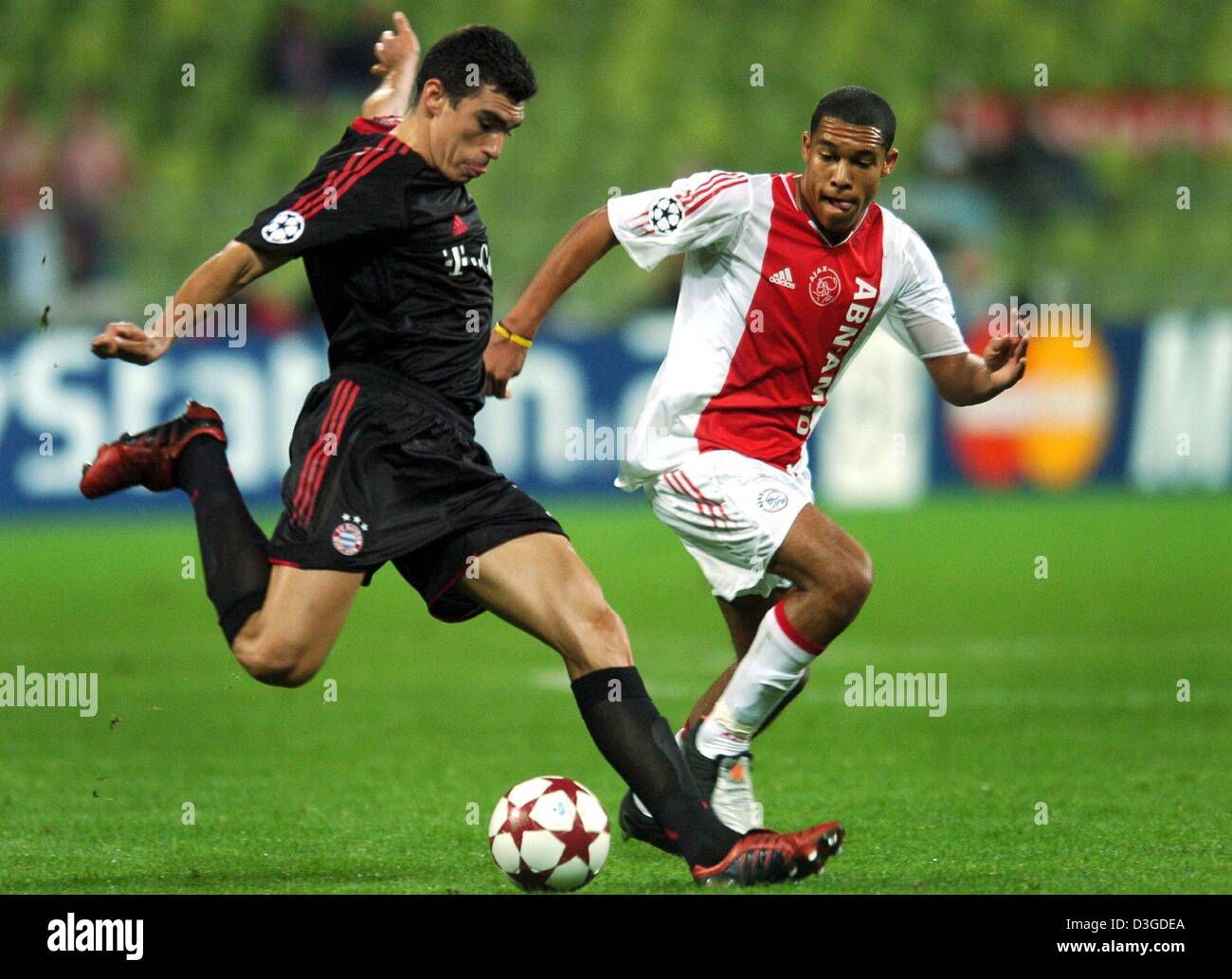 (Afp) - Bayern defender Lucio (L) se bat pour la balle avec Ajax's Nigel De Jong dans le match de la Ligue des Champions entre le Bayern Munich et l'Ajax d'Amsterdam au Stade olympique de Munich, Allemagne, 28 septembre 2004. Bayern a gagné 4-0. Banque D'Images