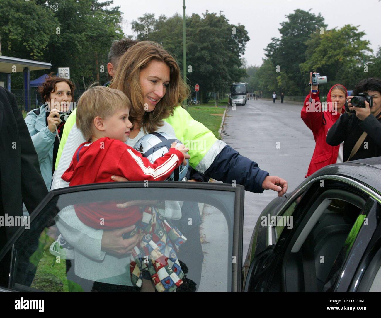 (Afp) - L'ancien joueur de tennis Allemande Steffi Graf avec son fils Jaden Gil quitte le stade après un match de football de charité à Berlin, le 26 septembre 2004. Les profits seront versés à la fondation Steffi Graf "Children for Tomorrow". Banque D'Images