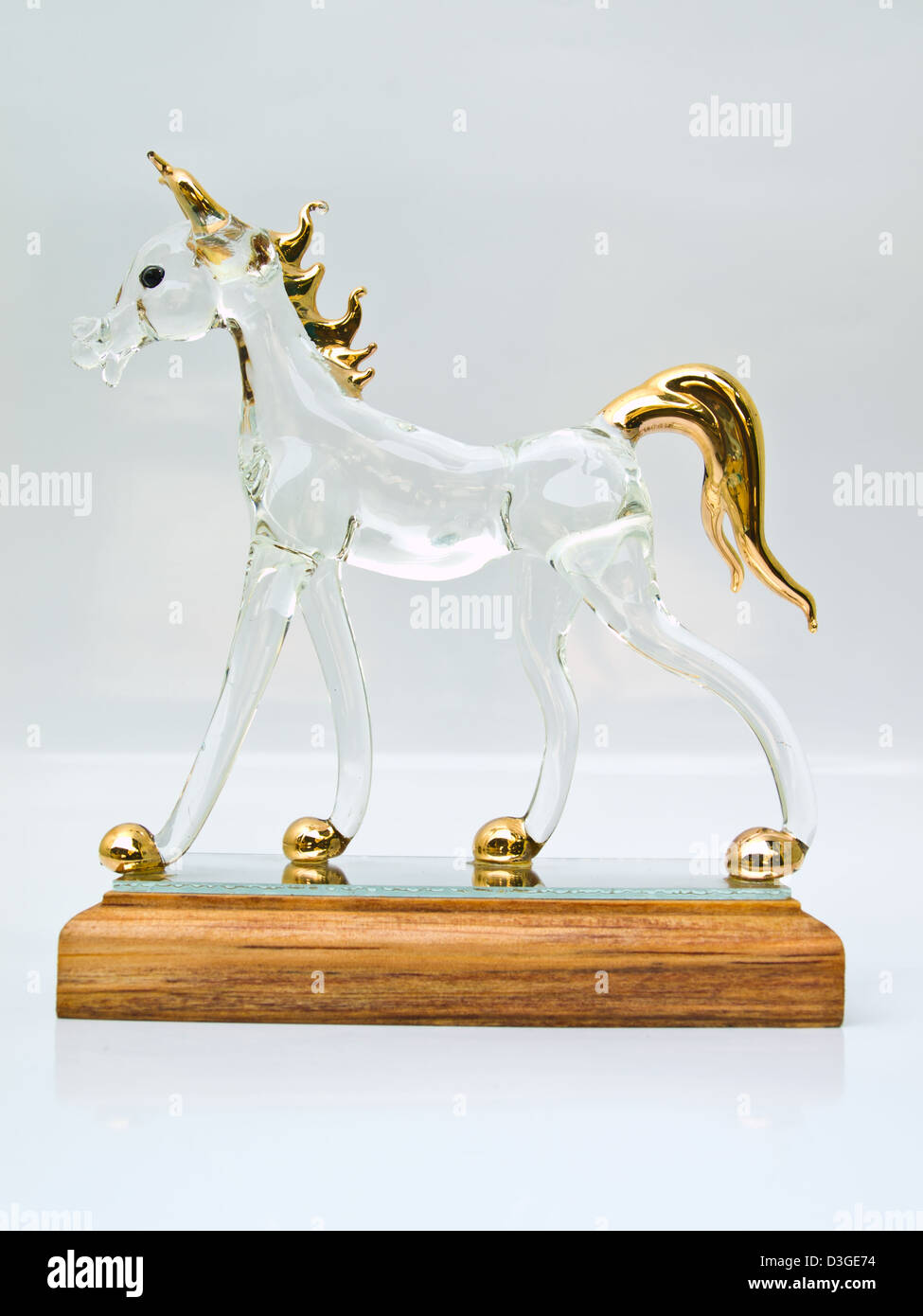 Un cheval en verre sur la plate-forme en bois isolé sur blanc Banque D'Images