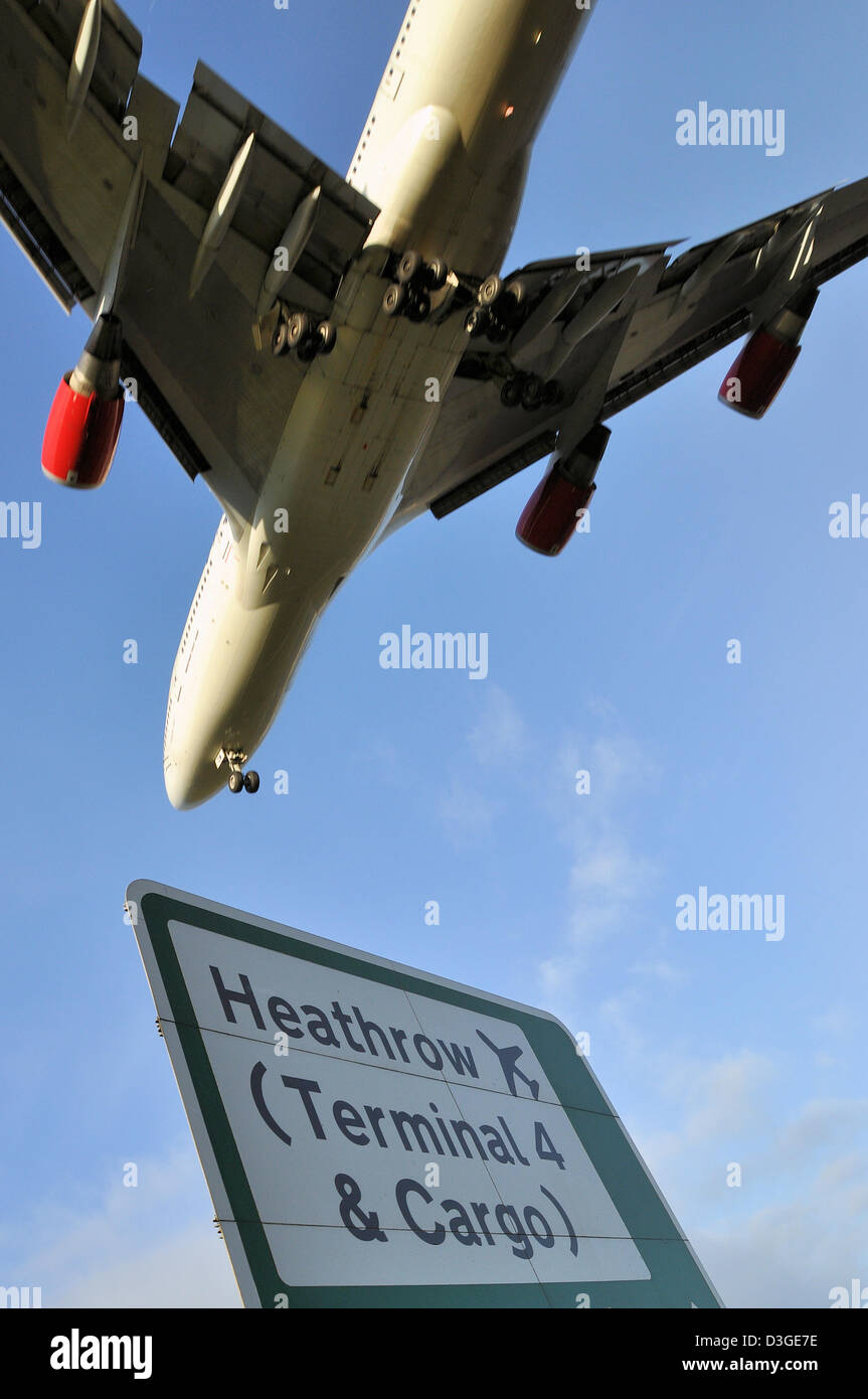 L'avion de ligne Boeing 747 à réaction atterrit à l'aéroport de Londres Heathrow, comme l'illustre le panneau routier. Jumbo Jet Banque D'Images