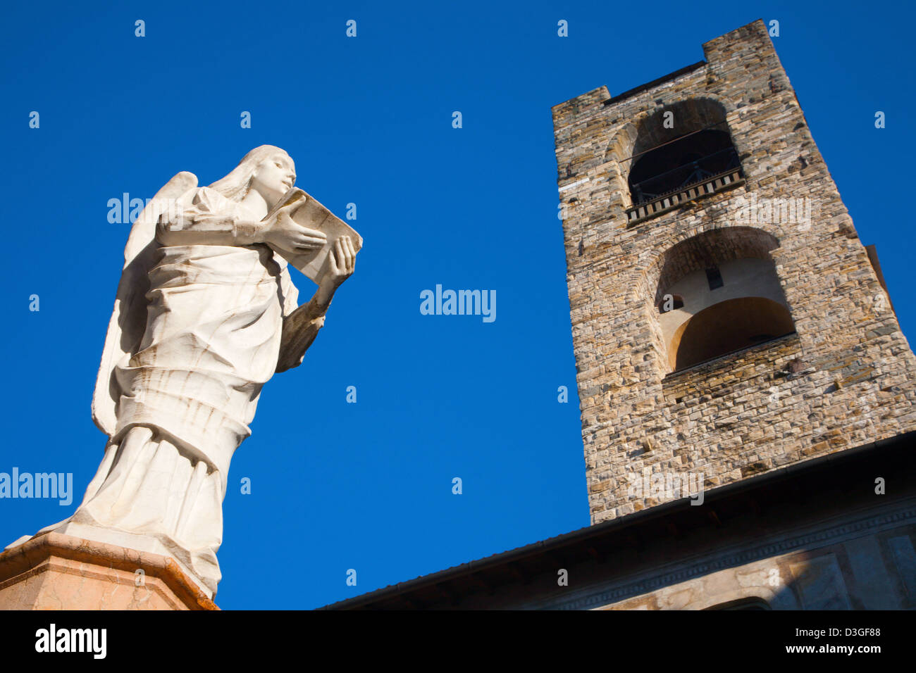 Bergame - Statue de la vertu du baptistère construit en 1340 par Giovanni da Campione sur la Piazza del Duomo et Torre del Comune Banque D'Images