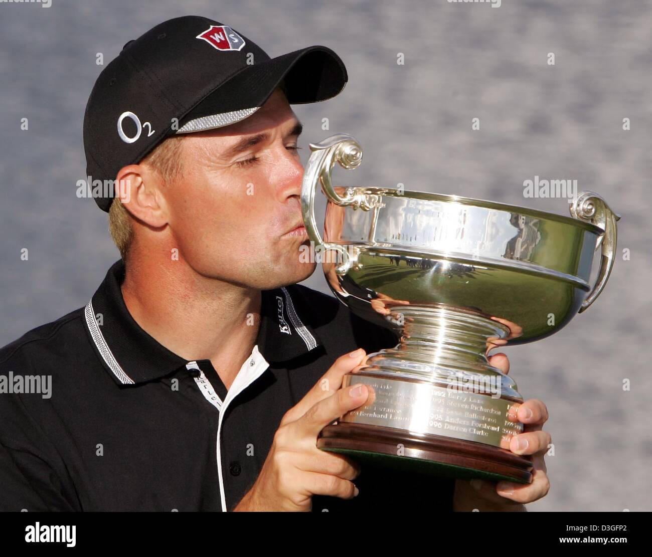 (Afp) - 33-year-old Irish golf pro Padraig Harrington embrasse le trophée après avoir remporté le tournoi de Golf Masters allemand sur la 72-par cours à Pulheim, Allemagne, 12 septembre 2004. C'était la septième Harrington triomphe en Europe depuis 1996. Banque D'Images