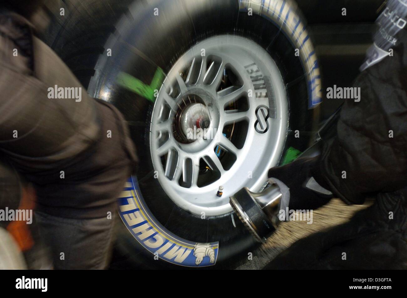 Afp) - Un mécanicien de McLaren Mercedes est titulaire d'un gonfleur  pneumatique pour gonfler le pneu d'une voiture de course de Formule Un que  la voiture s'arrête dans la voie des stands,