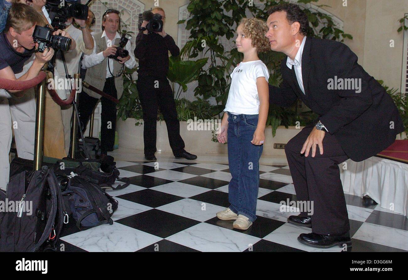 (Afp) - L'acteur américain Tom Hanks pose avec Olivia, la petite fille de l'un des photographes, au cours d'une photo appel à son nouveau film 'Terminal' à Berlin, le lundi 6 septembre 2004. Banque D'Images