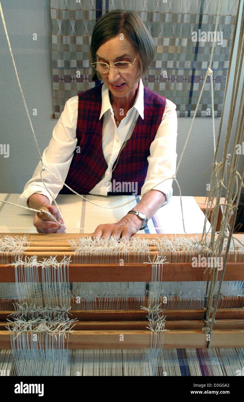 (Afp) - Weaver Erika Arndt travaille sur l'un de ses métiers à la main dans son atelier de Hildesheim, Allemagne, 18 août 2004. Elle donne également des ateliers pour enseigner à des personnes qui souhaitent les handweaving tissage amateur. Banque D'Images
