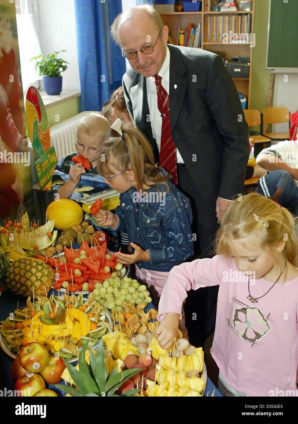 (Afp) - sur leur toute première journée d'école les élèves de la première année de l'école élémentaire la Nordstrasse remplir leur lunch avec fruits frais à Brême, Allemagne, 23 août 2004. Ministre de l'éducation de Brême Willy Lemke (R) regarde sur. Dans le cadre d'un programme sous la devise "l'école de départ avec des vitamines' 5 000 élèves des écoles publiques ont reçu un carton jaune à lunch avec ingredi sain Banque D'Images