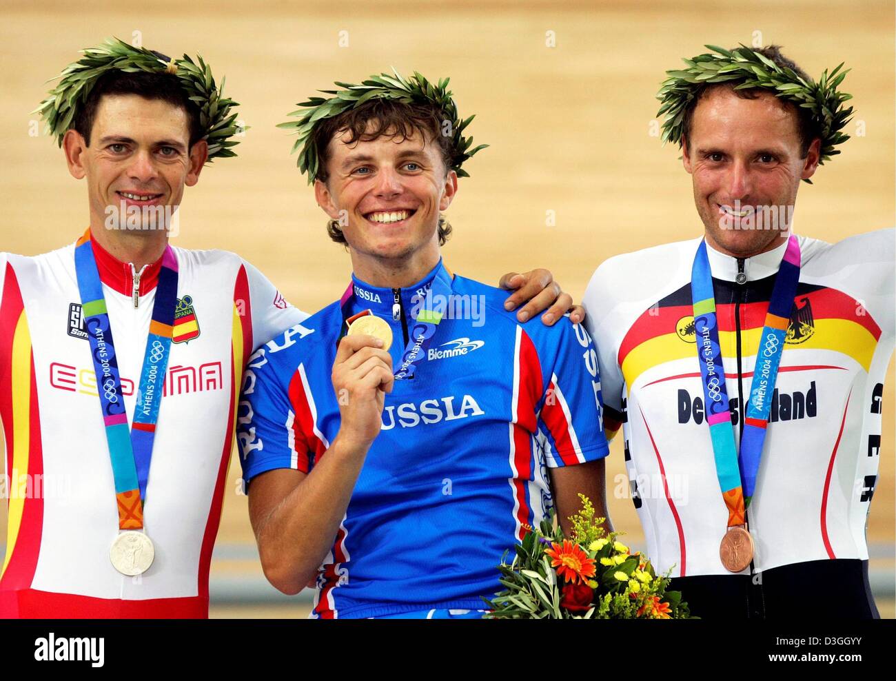 (Afp) - Mikhail Ignatiev (C) de la Russie, Joan Llaneras (L) de l'Espagne et Guido Fulst (R) de l'Allemagne sur le podium et présenter leurs médailles après le point d'hommes course de cyclisme sur piste aux Jeux Olympiques de 2004 à Athènes, Grèce, 24 août 2004. Ignatiev a remporté l'or, argent et Fulst Llaneras ont pris le bronze. Banque D'Images