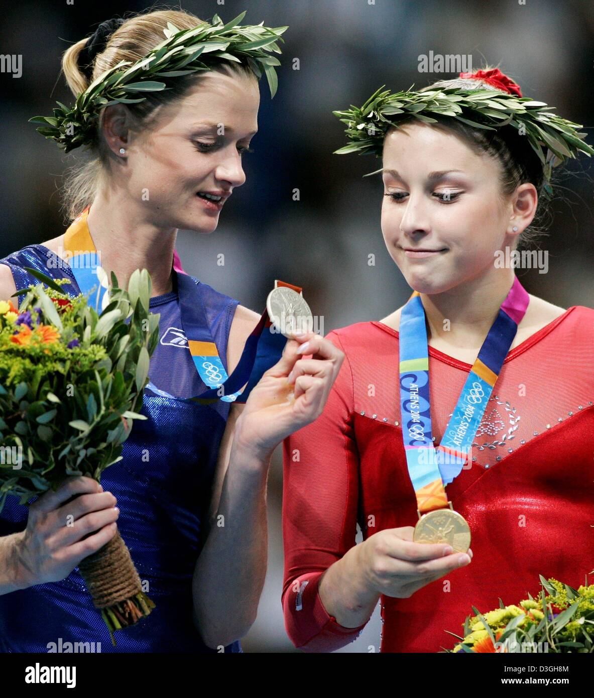 (Afp) - Svetlana Khorkina gymnaste russe (L) et Carly Patterson de la monter sur le podium et d'autres leurs médailles après l'individu tout autour de la gymnastique en finale des Jeux Olympiques 2004 à la salle omnisports d'Elliniko à Athènes, Grèce, le 19 août 2004. Patterson a remporté l'or et argent Khorkina. Banque D'Images