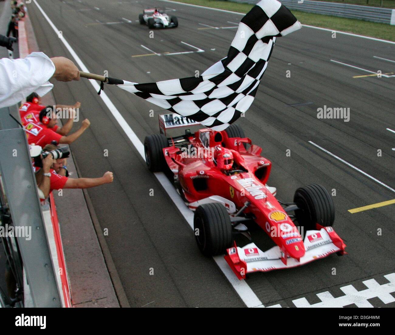 (Afp) - L'Allemand Michael Schumacher, pilote de Formule 1 courses avec sa Ferrari passé le drapeau à damier qu'il remporte le Grand Prix de Formule 1 du circuit de course sur le Hungaroring à Budapest, Hongrie le 15 août 2004. Schumacher est maintenant en mesure de fixer son septième titre de champion du monde dans la prochaine course de Formule 1. Banque D'Images