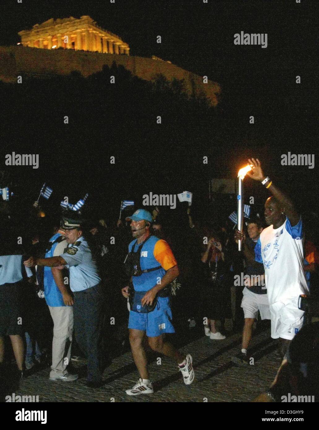 (Afp) - 9 fois médaillé d'or olympique Carl Lewis du nous porte la flamme olympique au pied de l'Acropole comme la tour du monde olympique relais atteint sa phase finale, à Athènes, jeudi 12 août 2004. Le vendredi le flambeau arrivera au Stade olympique à Athènes pour le coup d'envoi des Jeux Olympiques de 2004 à Athènes. Banque D'Images