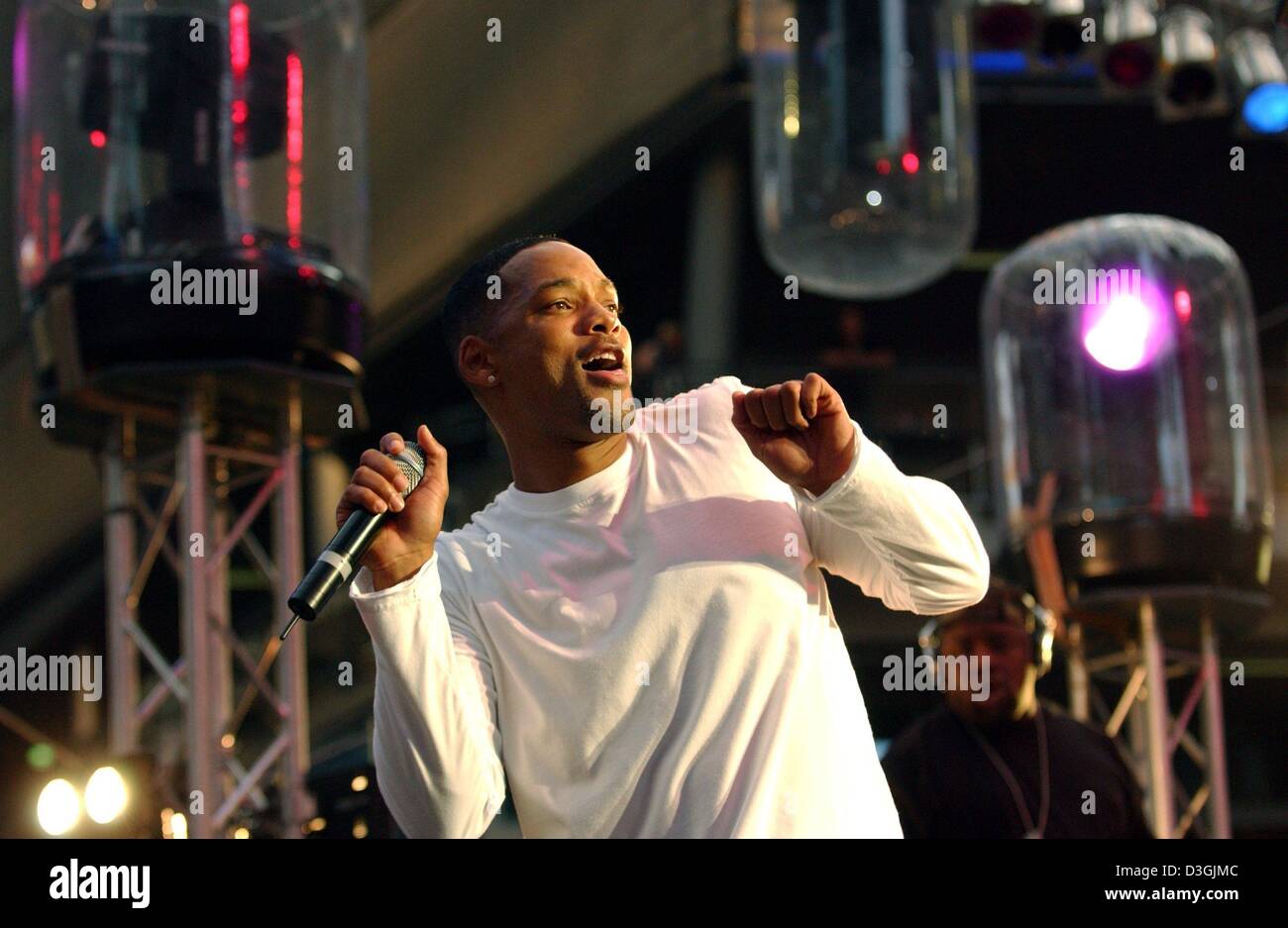 (Afp) - L'acteur américain Will Smith joue sur la scène lors d'un court concert rap pour ses fans avant la première Allemande de son nouveau film "I, Robot" à Berlin, 02 août 2004. Banque D'Images