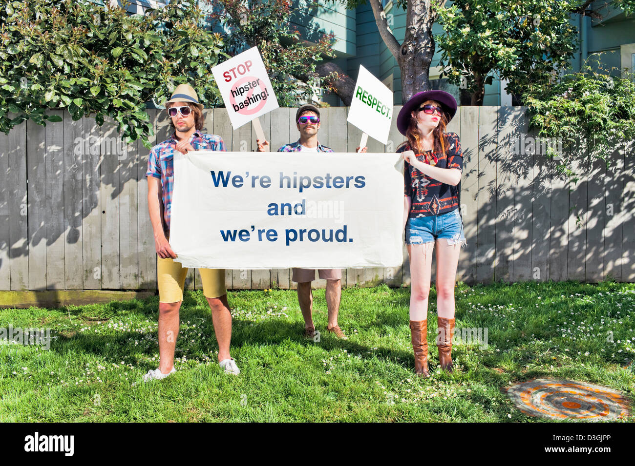 Les gens branchés et Beatniks - Trois hipsters manifestant contre hipster-bashing, tenant des pancartes, panneaux, bannières et Banque D'Images