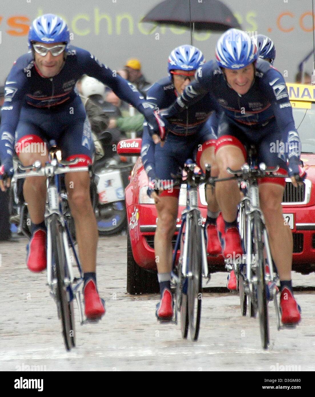 (Dpa) - US cycliste Lance Armstrong (R) de l'équipe US Postal Services et son coéquipier et compatriote George Hinacapie (L) courage lorsqu'ils franchissent la ligne d'arrivée après la course contre la montre par équipe à la quatrième étape du Tour de France menant de Cambrai à Arras, France, 7 juillet 2004. Même la pluie torrentielle durant la course contre la montre par équipe de Cambrai à Arras ne pouvait pas arrêter les 32 ans-o Banque D'Images