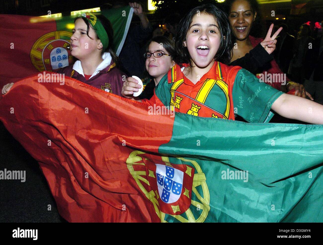 (Afp) - des fans portugais cheers et jubilate dans les rues de Hambourg, Allemagne, 24 juin 2004, après le Portugal a remporté le match de football Euro 2004 contre l'Angleterre sur la sanction. Banque D'Images