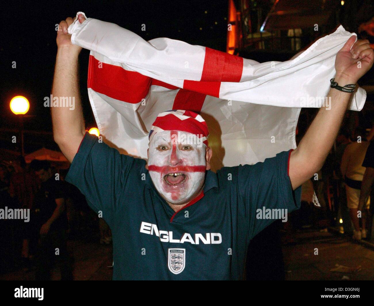 (Afp) - Un fan de foot, avec la croix de Saint-Georges-peint sur le visage, des acclamations et des jubilates avec le drapeau anglais dans ses mains à travers les rues de Lisbonne, Portugal, 21 juin 2004. L'Angleterre a gagné leur dernier euro 2004 Football match du groupe B contre la Croatie 4-2 et qualifié pour le quart de finale, tandis que la Croatie a chuté hors de la concurrence. Banque D'Images