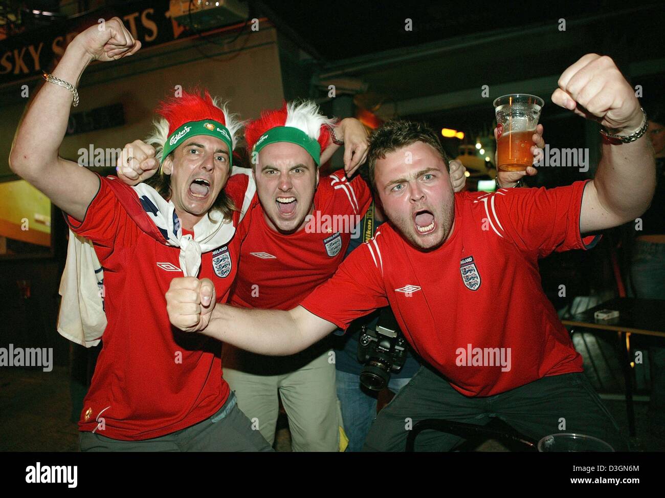 (Afp) - des fans de football anglais cheer et célébrer dans les rues de Lisbonne, Portugal, 21 juin 2004. L'Angleterre a gagné leur dernier euro 2004 Football match du groupe B contre la Croatie 4-2 et qualifié pour le quart de finale, tandis que la Croatie a chuté hors de la concurrence. Banque D'Images