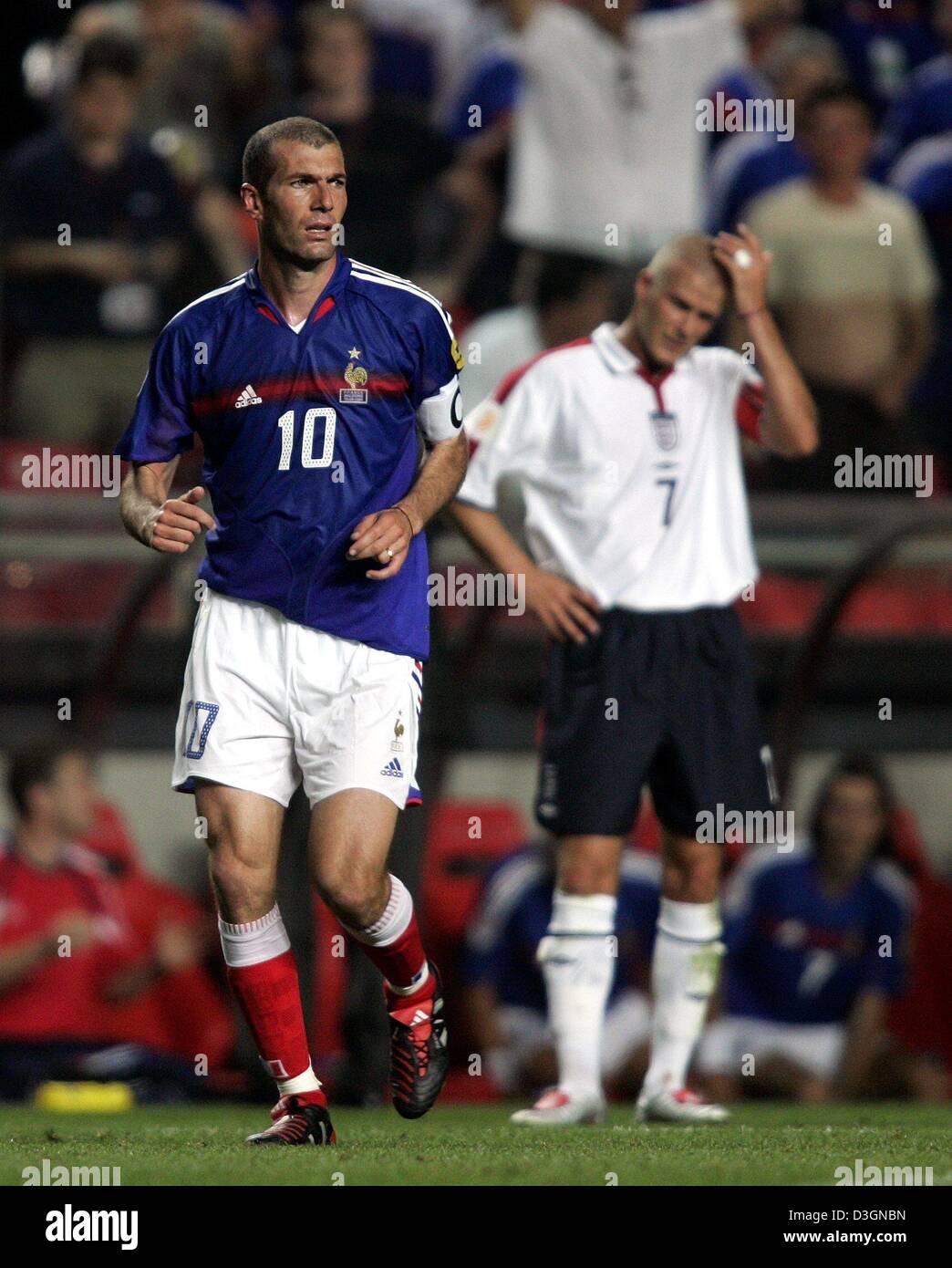 (Afp) - L'équipe nationale française mastermind Zinedine Zidane s'exécute sur le terrain au cours de l'Euro 2004 groupe B match contre l'Angleterre à Lisbonne, le 13 juin 2004. Dans l'arrière-plan l'Angleterre joueur David Beckham peut être vu. La France rencontrera la Suisse dans leur dernier match de groupe, le lundi 21 juin et peux qualification pour les quarts de finale avec une victoire. Banque D'Images