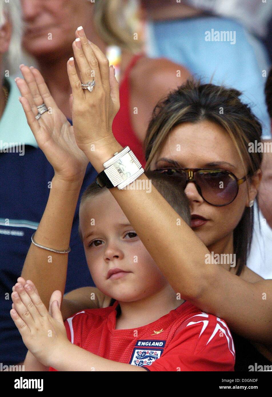 (Dpa) - Victoria Beckham (L), épouse du milieu de terrain Anglais David Beckham, et leur fils Brooklyn applaudir leurs mains comme ils suivent l'Euro de football 2004 Jeu de groupe s'opposant à l'Angleterre et la Suisse à la cidade Stadium à Coimbra, Portugal, 17 juin 2004. L'Angleterre a gagné 3-0.  + + +PAS D'APPLICATIONS DE TÉLÉPHONIE MOBILE + + + Banque D'Images
