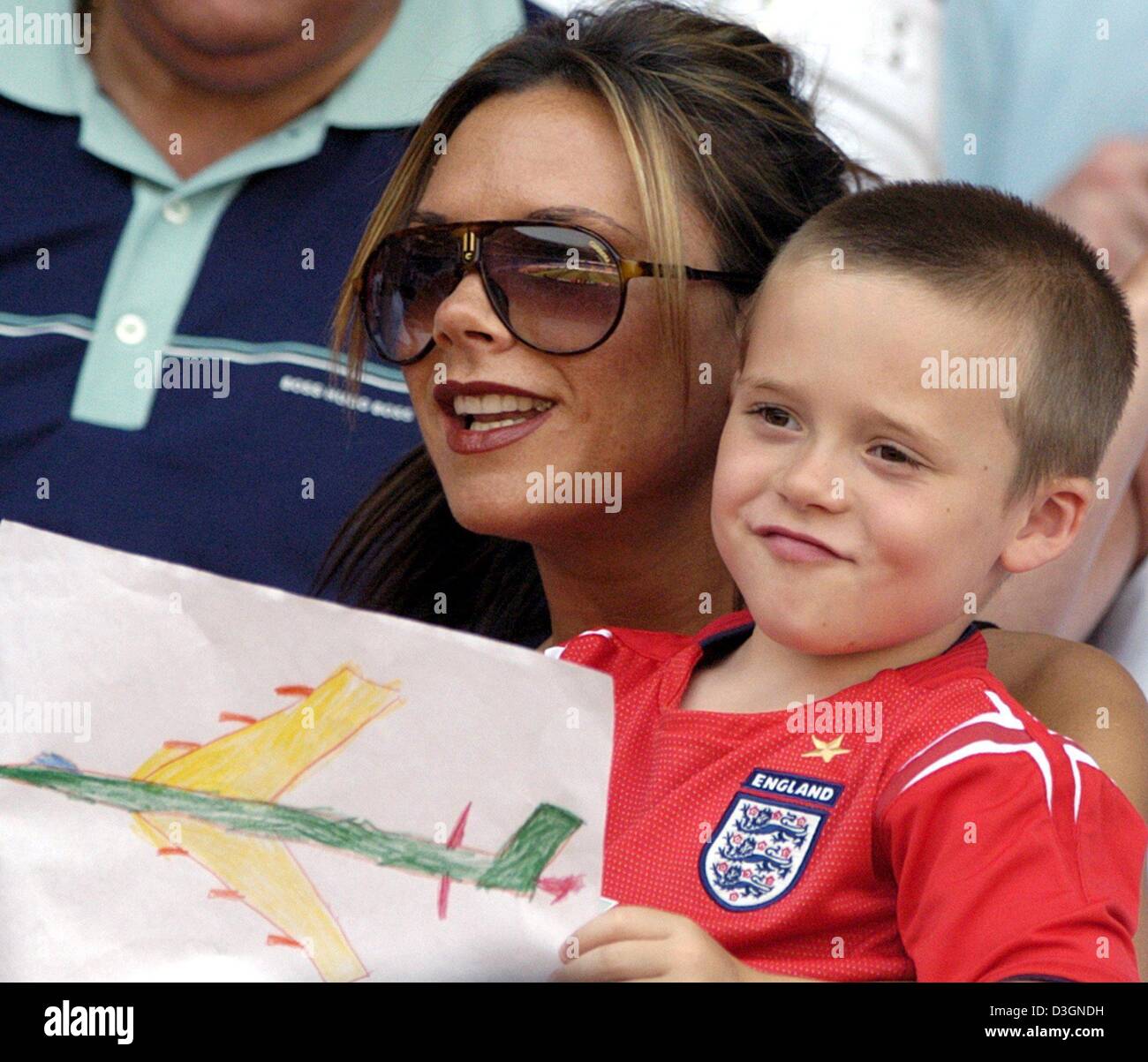 (Dpa) - Victoria Beckham (L), épouse du milieu de terrain Anglais David Beckham, et leur fils Brooklyn sourire alors qu'ils suivent l'Euro de football 2004 Jeu de groupe s'opposant à l'Angleterre et la Suisse à la cidade Stadium à Coimbra, Portugal, 17 juin 2004. L'Angleterre a gagné 3-0.  + + +PAS D'APPLICATIONS DE TÉLÉPHONIE MOBILE + + + Banque D'Images