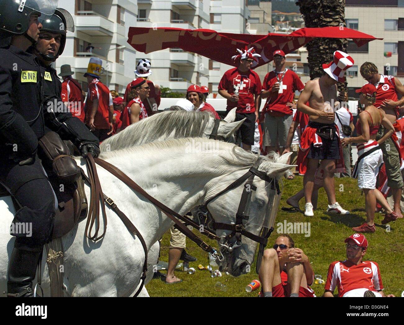 (Afp) - Des agents de police portugais monté monter sur leurs chevaux passé un groupe de fans de football suisse avant le début de l'Euro de football 2004 Jeu de groupe s'opposant à l'Angleterre et la Suisse à la cidade Stadium à Coimbra, Portugal, 17 juin 2004. Cependant, à la fin de la Suisse a perdu 0-3.  + + +PAS D'APPLICATIONS DE TÉLÉPHONIE MOBILE + + + Banque D'Images