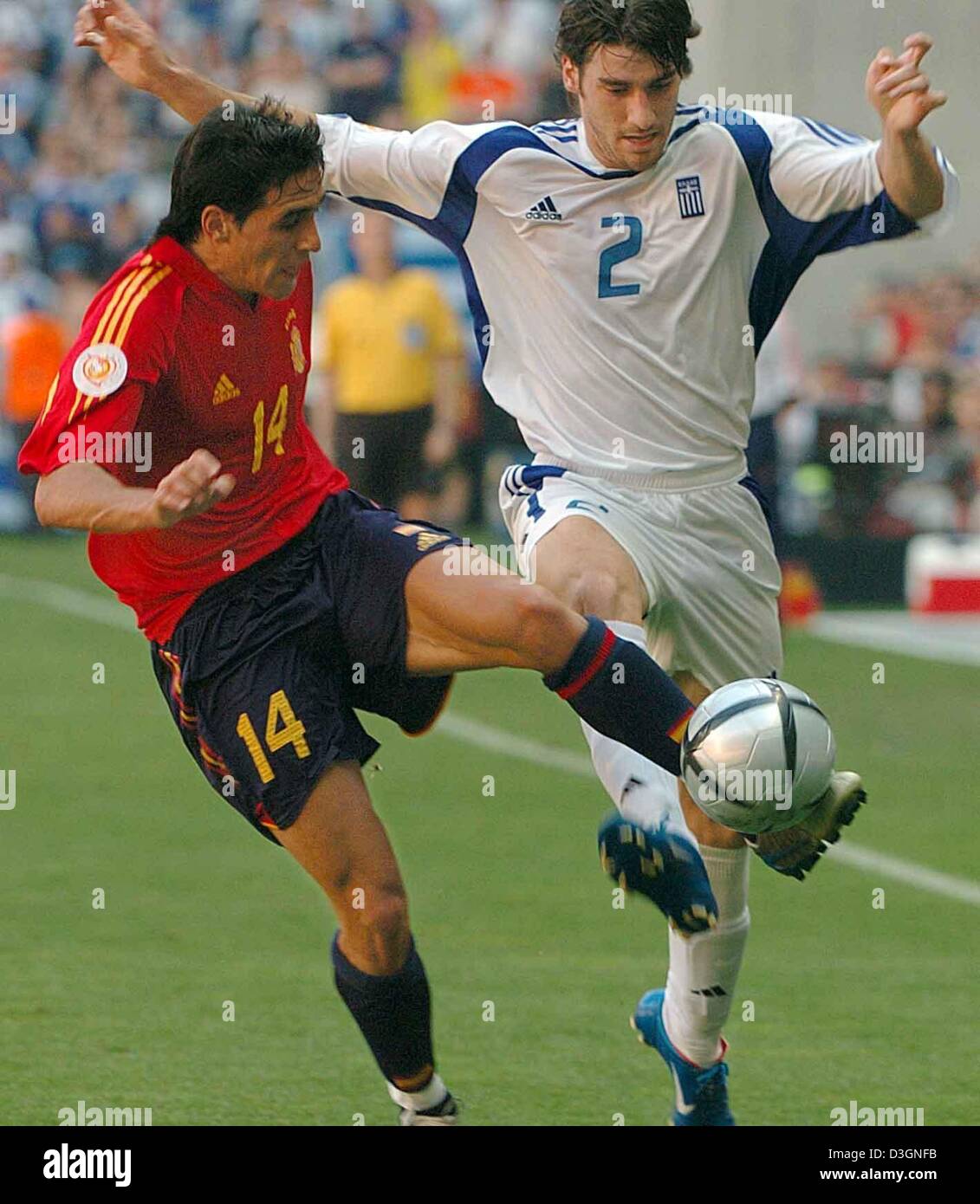 Afp) - Le milieu de terrain de l'Espagne Vicente (L) duels avec défenseur  grec Georgios Seitaridis pendant l'Euro de football 2004 Jeu de groupe  s'opposant à l'Espagne et la Grèce au stade