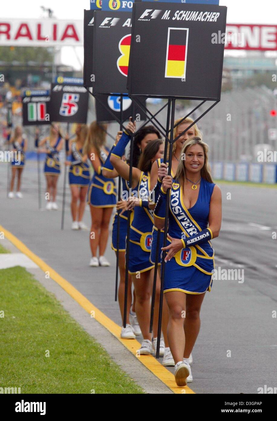 (Dpa) Grid-girls avec le numéro de départ du champion du monde de F1 allemand Michael Schumacher à l'avant à pied peu de temps avant le début de l'Australian GP sur le 'Albert Park Racetrack' le dimanche, 7 mars 2003 à Melbourne. Banque D'Images