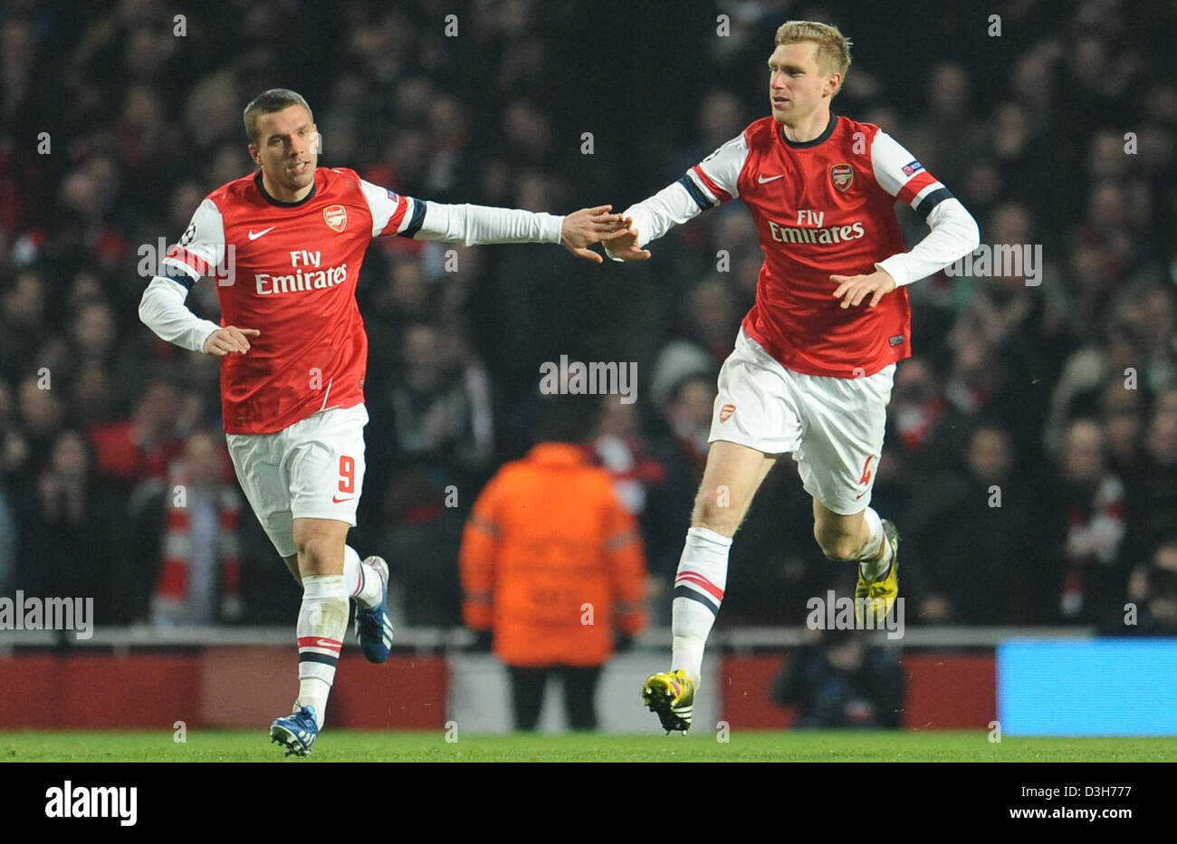 L'arsenal Lukas Podolski (L) célèbre avec p. Mertesacker après avoir marqué le 1-2 au cours de la Ligue des Champions Tour de jambe premier 16 match de foot entre Arsenal FC et le FC Bayern de Munich à l'Emirates Stadium à Londres, Angleterre, le 19 février 2013. Photo : Andreas Gebert/dpa  + + +(c) afp - Bildfunk + + + Banque D'Images