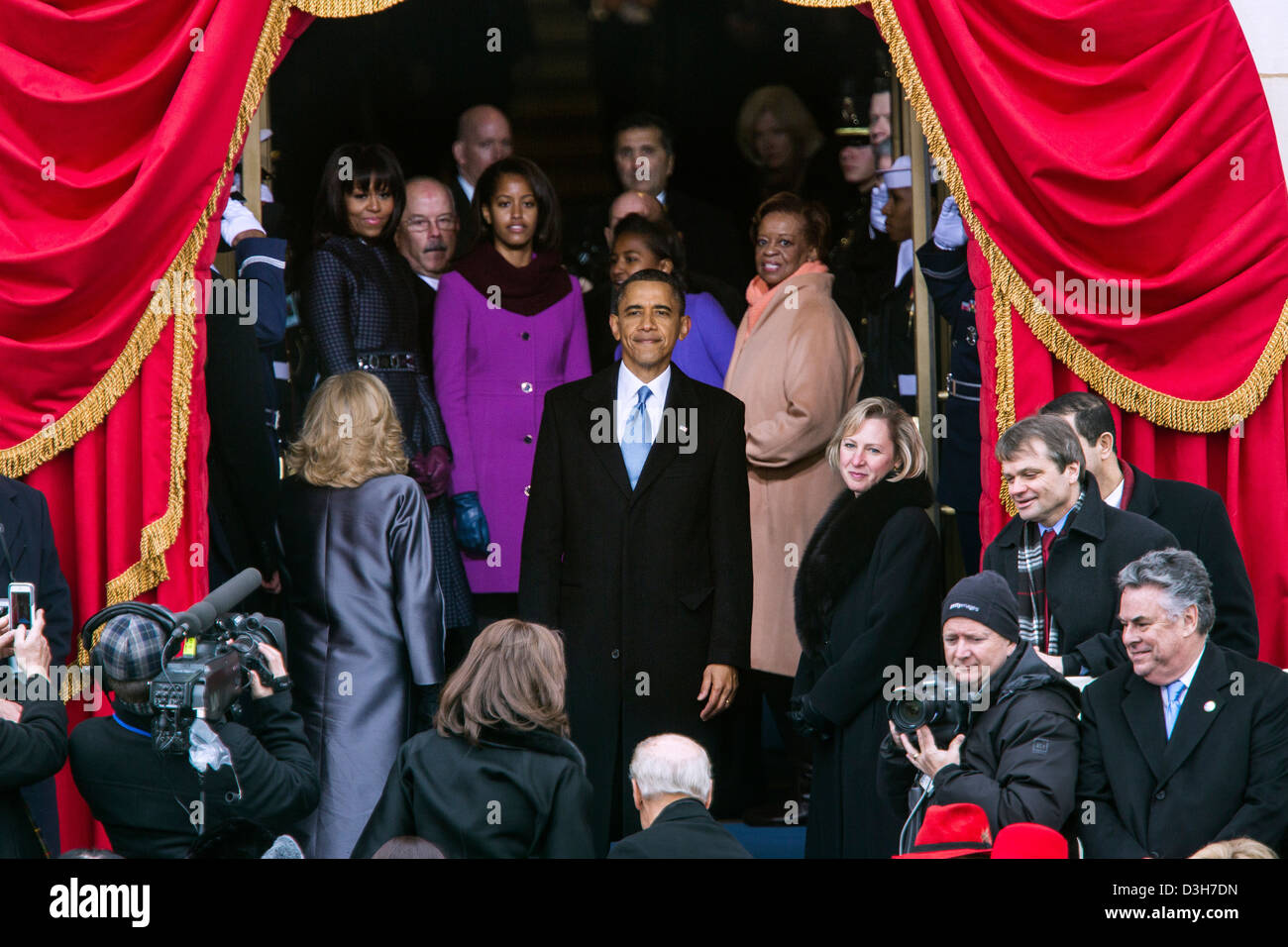 Le président américain Barack Obama s'arrête pour regarder en arrière sur les lieux avant de quitter la plate-forme à la suite de la séance inaugurale d'assermentation au Capitole le 21 janvier 2013 à Washington, DC. Debout derrière le président sont la Première Dame Michelle Obama, ses filles Malia et Sasha, et Marian Robinson. Banque D'Images