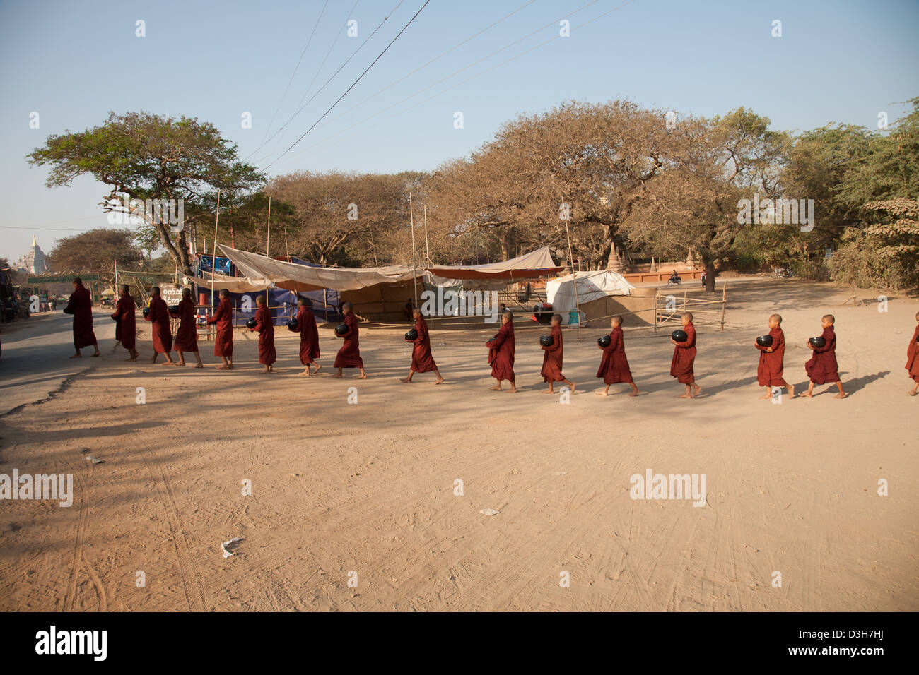 Moines à Bagan la collecte de l'aumône au lever du soleil Banque D'Images