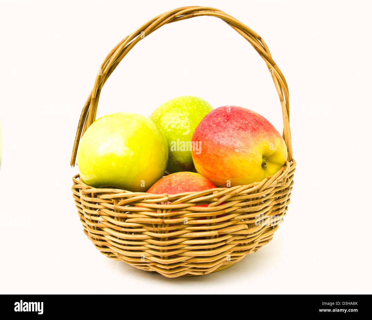 Pommes vertes et rouges dans un panier isolated on white Banque D'Images