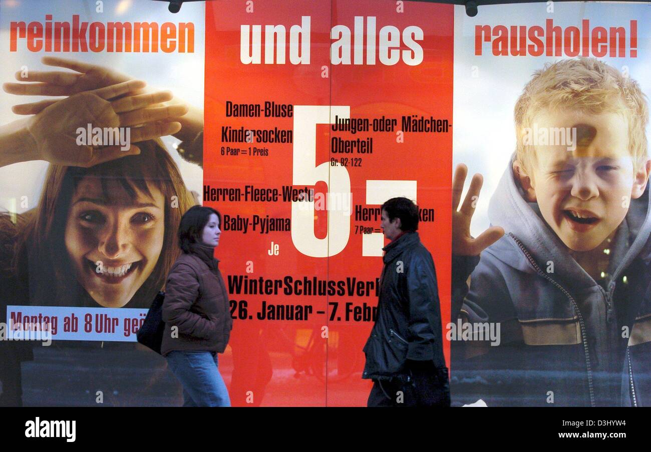 (Afp) - Un des passants devant une affiche qui annonce les soldes d'hiver dans un grand magasin à Munich, Allemagne, 26 janvier 2004. Avec des réductions jusqu'à 70 pour cent, les détaillants ont maintenant commencé la vente d'hiver pour cette saison.avec remise de prix le commerce de détail est l'espoir de compenser les mauvais chiffres d'affaires de ces derniers mois. Banque D'Images