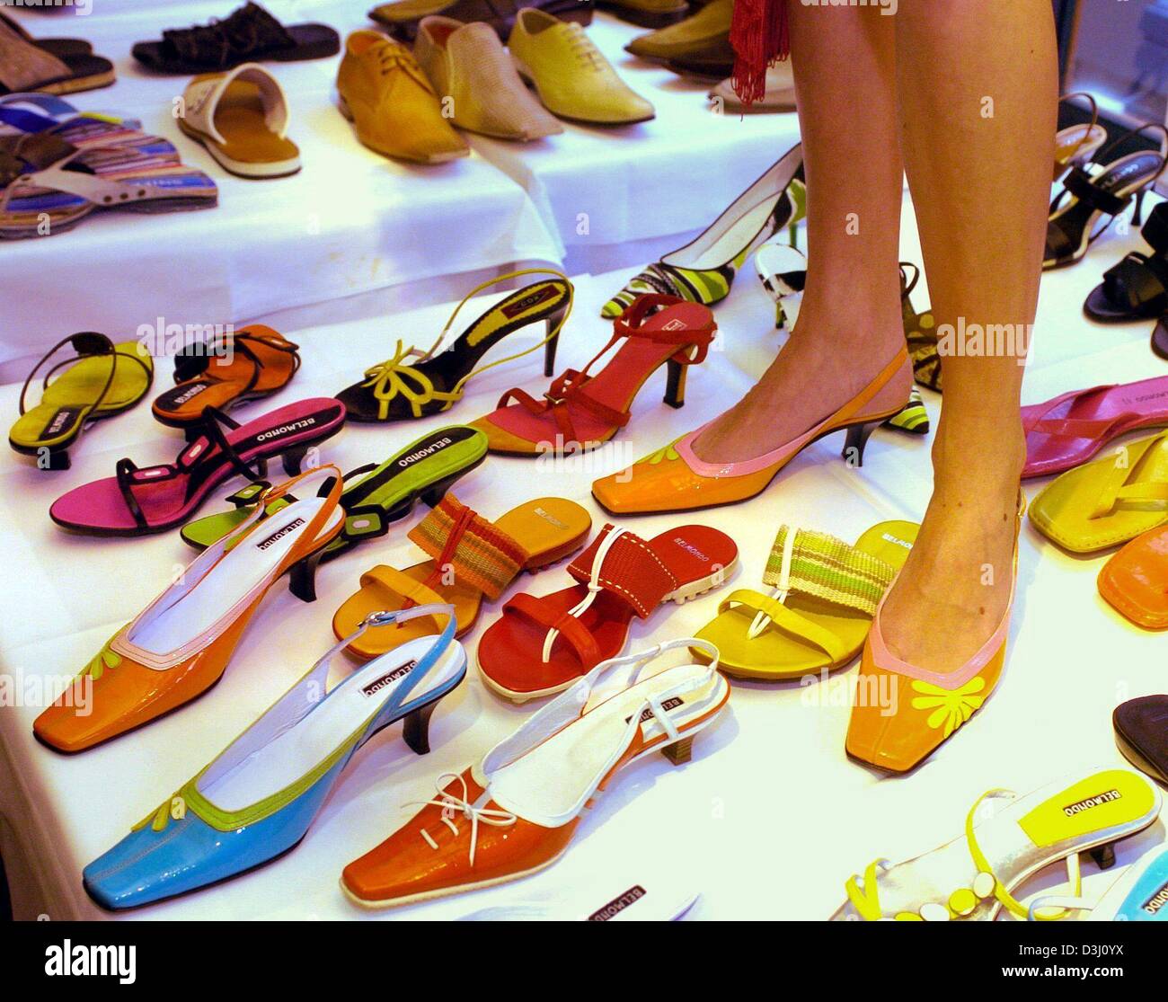 Afp) Un modèle est sur table couverte de chaussures pendant une  présentation d'Goertz-Belmondo à Hambourg le 12 février 2004. Les chaussures  dans la saison printemps/été 2004 sont très colorées, mais aussi offrir