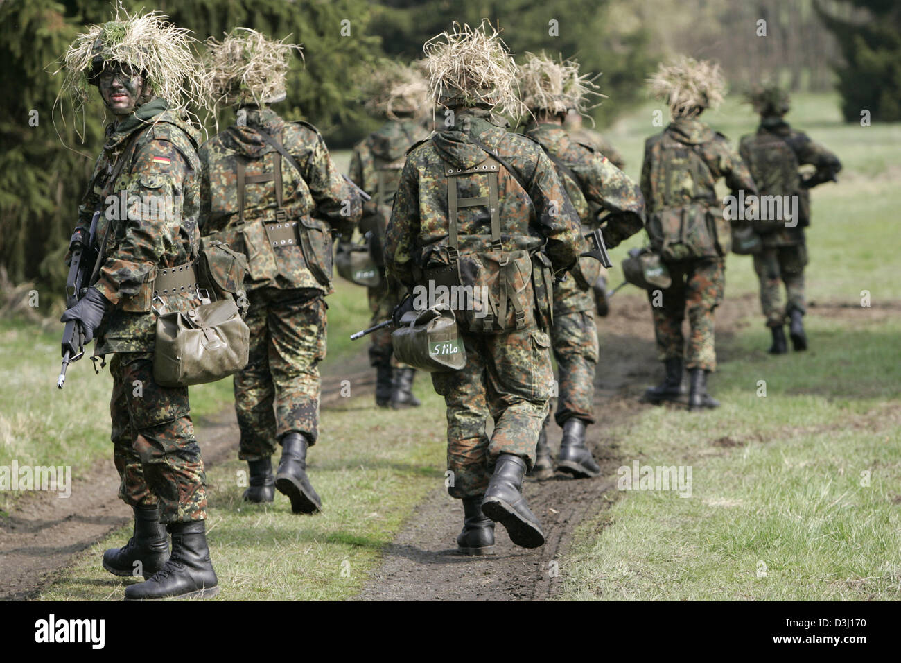 (Afp) - Un groupe d'appelés de la division d'infanterie de la Bundeswehr, une tenue de camouflage et armé d'un fusil G36, fixer un chemin forestier au cours d'un exercice sur le terrain dans le cadre de la formation militaire de base à la caserne en Knuell Schwarzenborn, Allemagne, 14 avril 2005. Banque D'Images