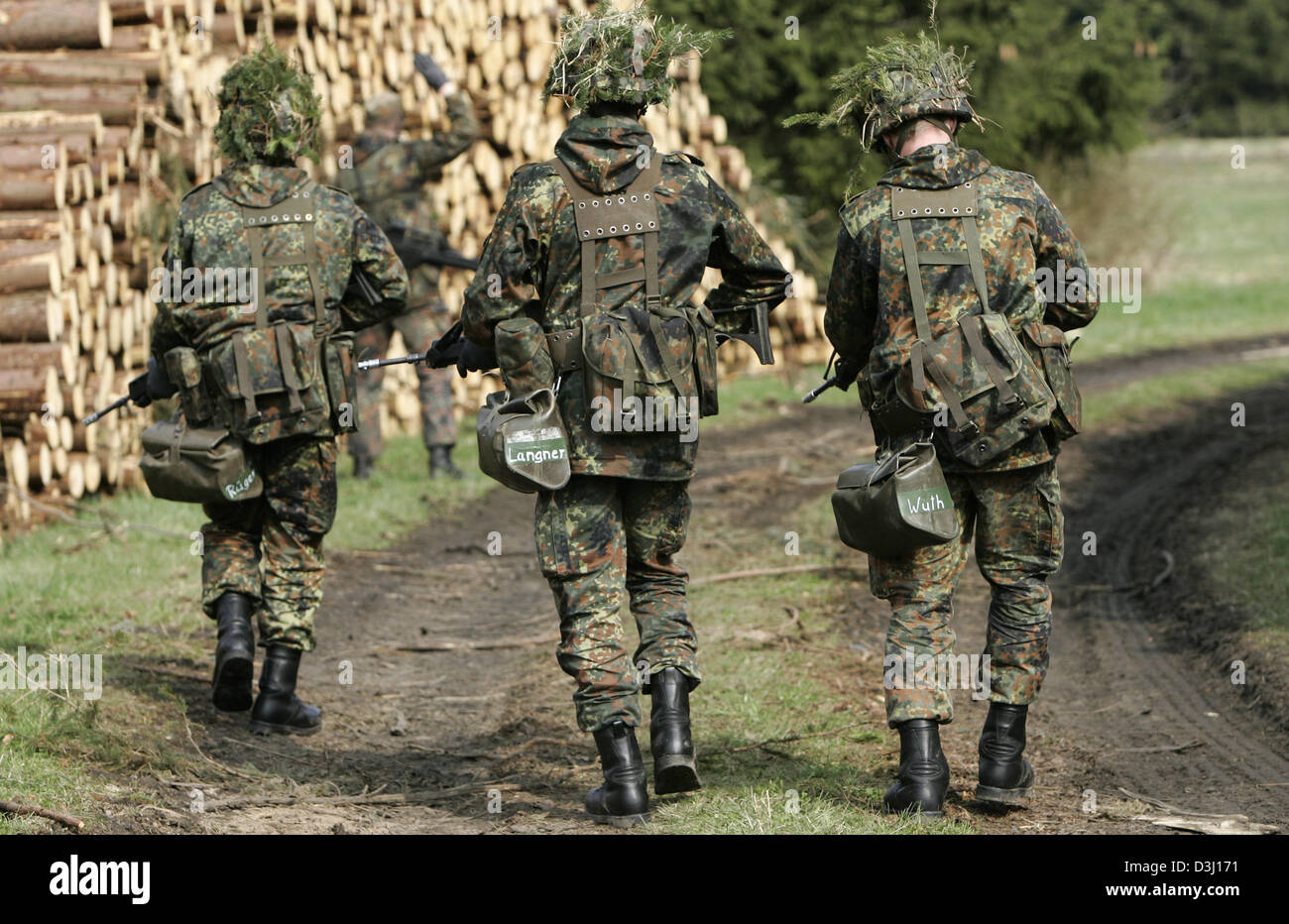 (Afp) - Un groupe d'appelés de la division d'infanterie de la Bundeswehr, une tenue de camouflage et armé d'un fusil G36, fixer un chemin forestier au cours d'un exercice sur le terrain dans le cadre de la formation militaire de base à la caserne en Knuell Schwarzenborn, Allemagne, 14 avril 2005. Banque D'Images