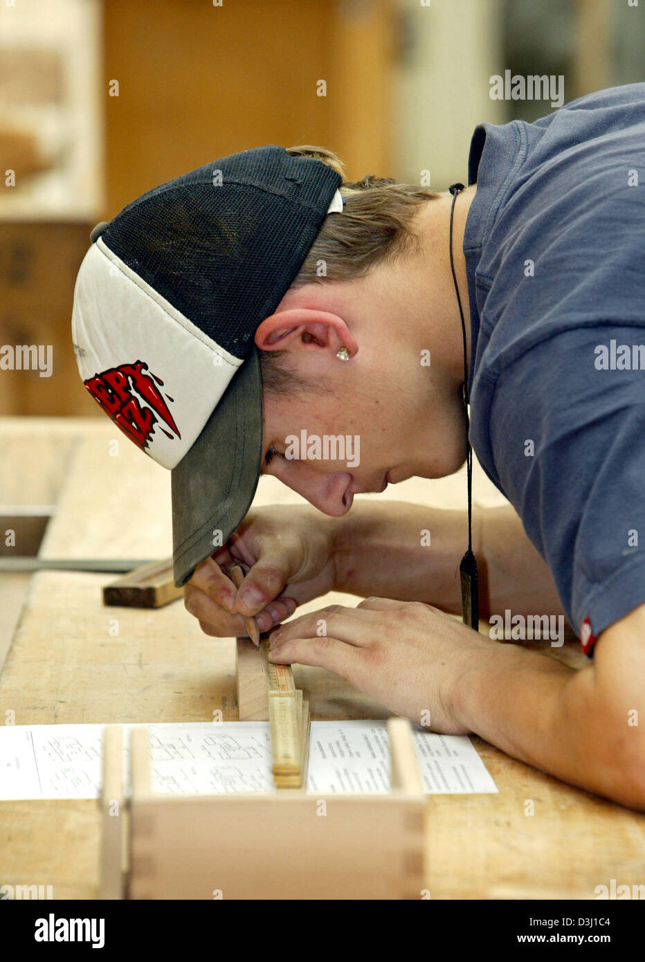 (Dpa) - Apprentissage Cem Hofer travaille sur un morceau de bois à une école de formation professionnelle à Kaufbeuren, Allemagne, 20 juillet 2005. Photo : Karl-Josef Opim Banque D'Images