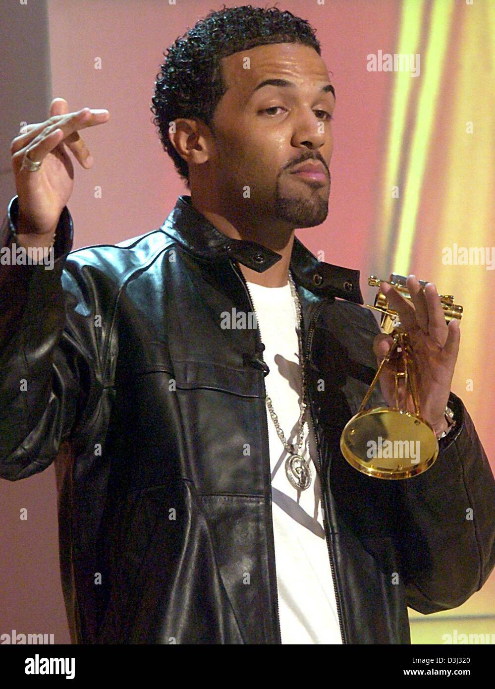 (Afp) - La chanteuse pop britannique Craig David pose avec son prix Caméra d'or à Berlin, 4 février 2004. Il a reçu le prix dans la catégorie 'International' Pop. À la veille de l'ouverture de la Berlinale la Caméra d'or a été accordé en 14 catégories pour la 39e fois par le German TV revue "Hoerzu" ("écouter"). Banque D'Images