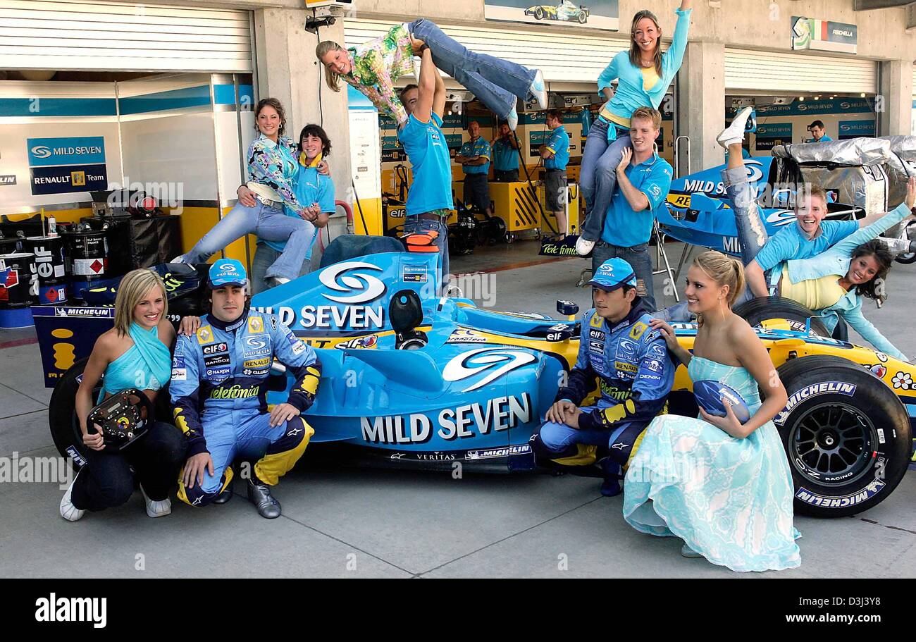 (Afp) - pilote de Formule 1 espagnol Fernando Alonso (L), son coéquipier italien l'Italien Giancarlo Fisichella (R) et les danseurs posent à côté d'une voiture de course Renault à l'US-piste Grand Prix de Formule 1 à Indianapolis, USA, 17 juin 2005. Le Grand Prix des Etats-Unis aura lieu le dimanche, 19 juin 2005. Banque D'Images