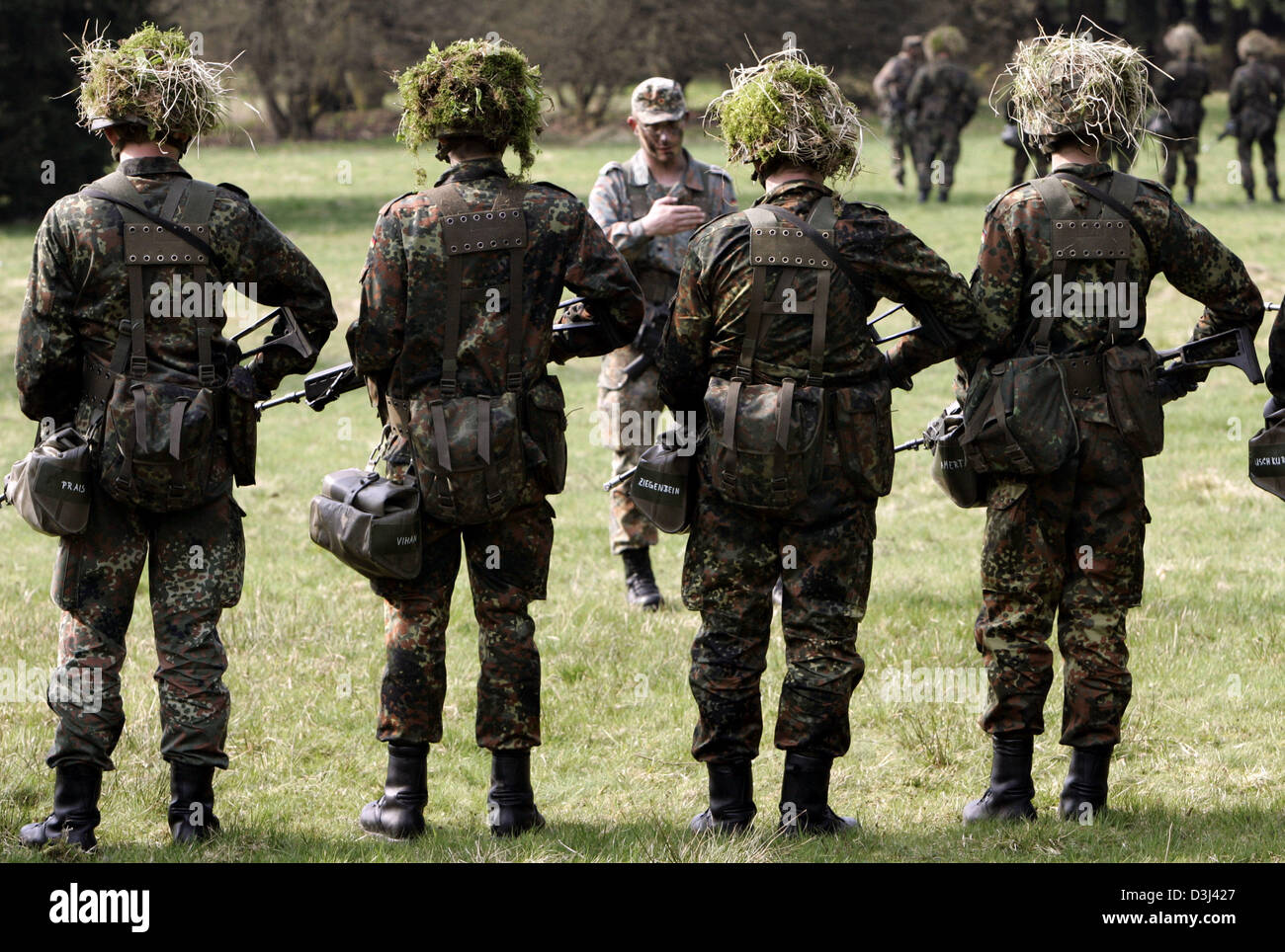 (Afp) - Un groupe de conscrit de la division d'infanterie de la Bundeswehr, une tenue de camouflage et armé d'un fusil G36, se tenir sur un terrain au cours d'un exercice sur le terrain dans le cadre de la formation militaire de base à la caserne en Knuell Schwarzenborn, Allemagne, 14 avril 2005. Banque D'Images