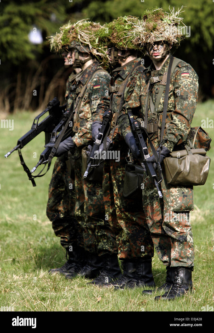 (Afp) - des conscrits de la division d'infanterie de la Bundeswehr allemande, une tenue de camouflage et armé d'un fusil G36, se tenir sur un terrain au cours d'un exercice sur le terrain dans le cadre de la formation militaire de base à la caserne en Knuell Schwarzenborn, Allemagne, 14 avril 2005. Banque D'Images