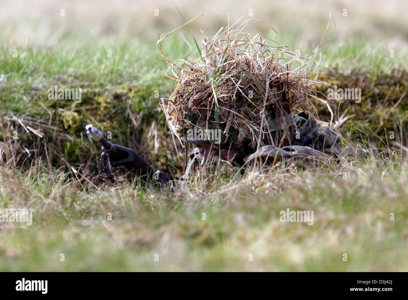 (Afp) - Le fichier photo, datée du 14 avril 2005, montre un conscrit de la division d'infanterie de la Bundeswehr, une tenue de camouflage, enlever le couvercle sur le sol avec son fusil G36 à un exercice sur le terrain dans le cadre de sa formation militaire de base à la caserne en Knuell Schwarzenborn, Allemagne, 14 avril 2005. Banque D'Images