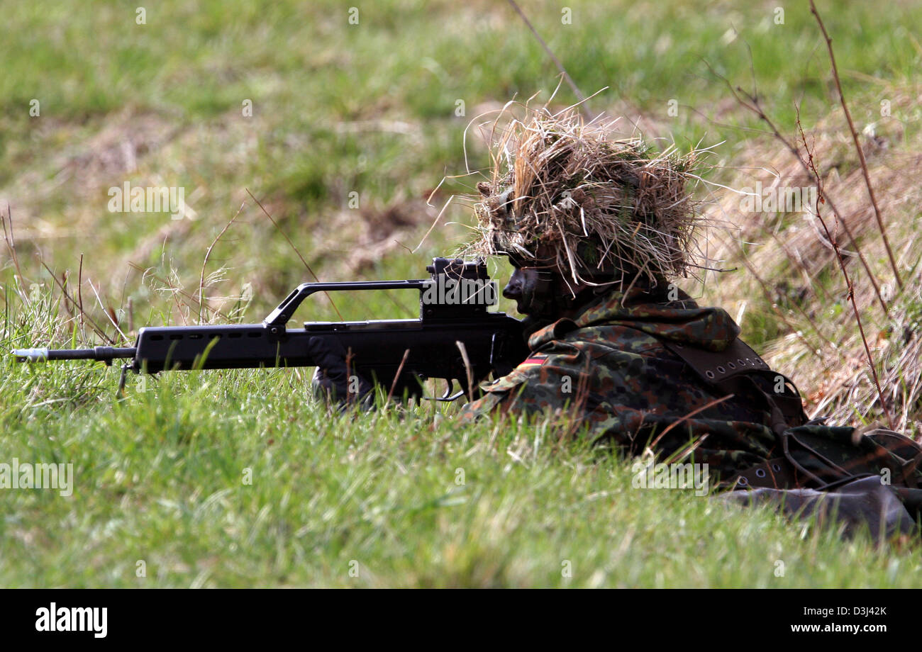 (Afp) - Le fichier photo, datée du 14 avril 2005, montre un conscrit de la division d'infanterie de la Bundeswehr, une tenue de camouflage, se coucher sur le sol et visez avec son fusil G36 à un exercice sur le terrain dans le cadre de sa formation militaire de base à la caserne en Knuell Schwarzenborn, Allemagne, 14 avril 2005. Banque D'Images