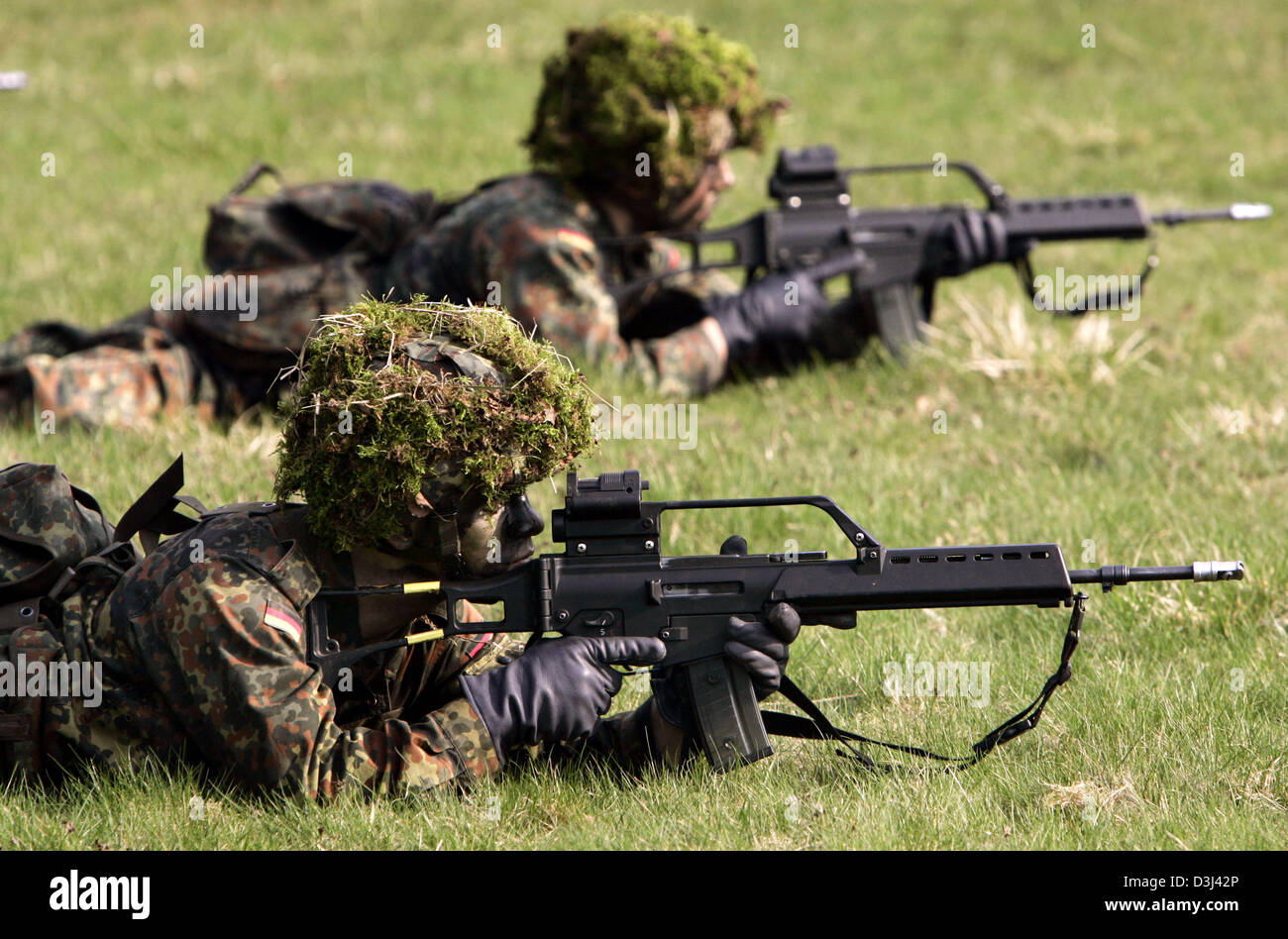 (Afp) - Le fichier photo, datée du 14 avril 2005, montre deux conscrits de la division d'infanterie de la Bundeswehr, une tenue de camouflage, enlever le couvercle sur le sol avec leur fusil G36 à un exercice sur le terrain dans le cadre de leur formation militaire de base à la caserne en Knuell Schwarzenborn, Allemagne, 14 avril 2005. Banque D'Images