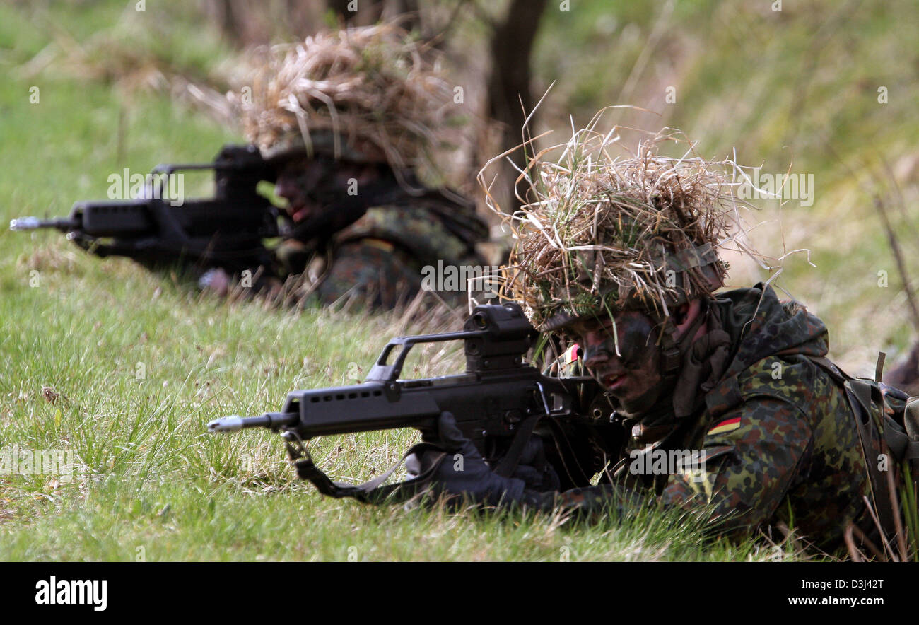 (Afp) - Le fichier photo, datée du 14 avril 2005, montre deux conscrits de la division d'infanterie de la Bundeswehr, une tenue de camouflage, enlever le couvercle sur le sol avec leur fusil G36 à un exercice sur le terrain dans le cadre de leur formation militaire de base à la caserne en Knuell Schwarzenborn, Allemagne, 14 avril 2005. Banque D'Images