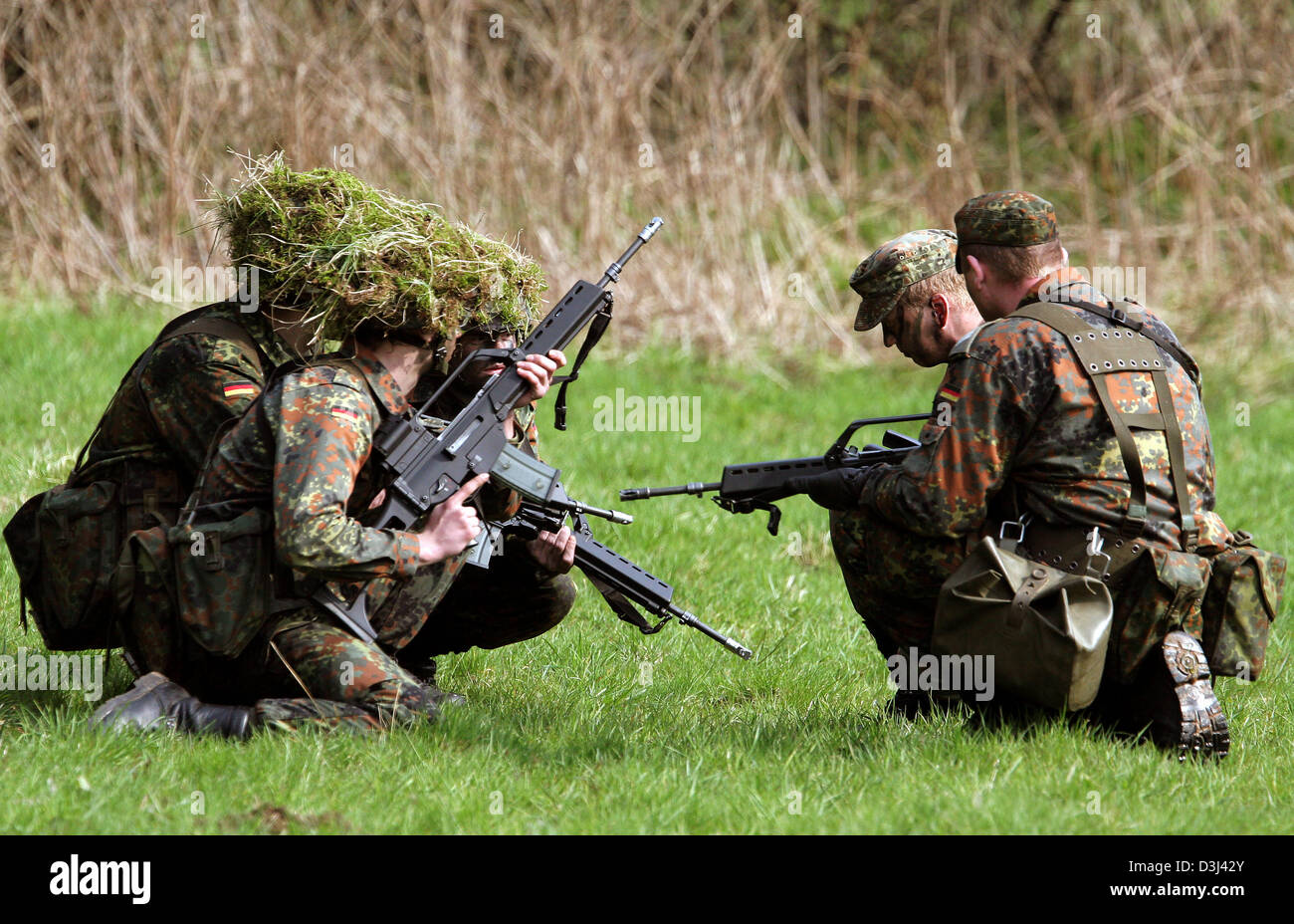 (Afp) - Le fichier photo, datée du 14 avril 2005, montre conscrits des véhicules blindés de combat d'infanterie division de la Bundeswehr allemande, tenue de camouflage, les squats avec leurs fusils G36 à un exercice sur le terrain dans le cadre de leur formation militaire de base à la caserne en Knuell Schwarzenborn, Allemagne, 14 avril 2005. Banque D'Images