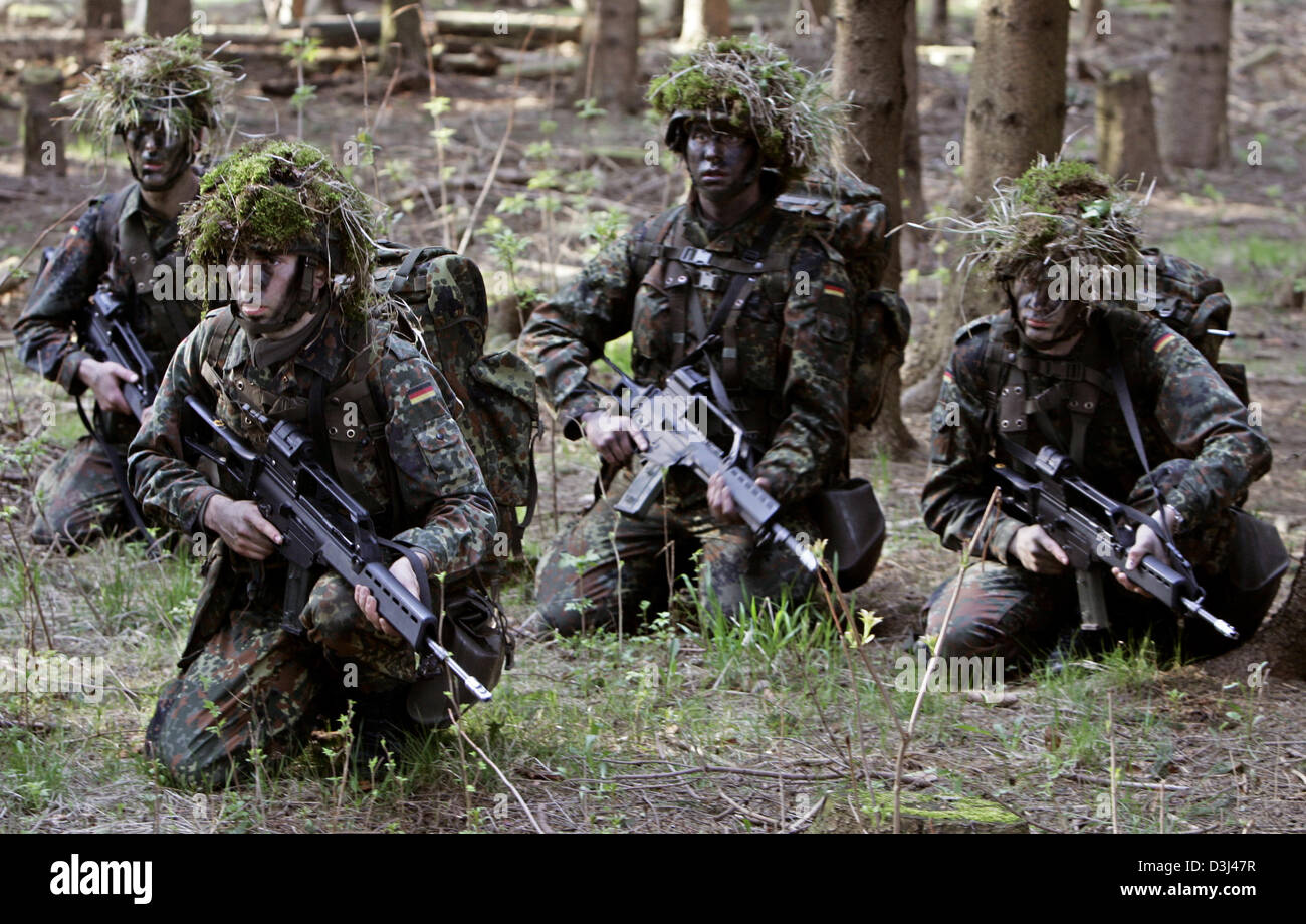 (Afp) - Un peloton de fantassins camouflés de la Bundeswehr, armés de fusils G36, s'agenouiller dans une forêt au cours d'un exercice sur le terrain dans le cadre de la formation militaire de base à la caserne en Knuell Schwarzenborn, Allemagne, 14 avril 2005. Banque D'Images