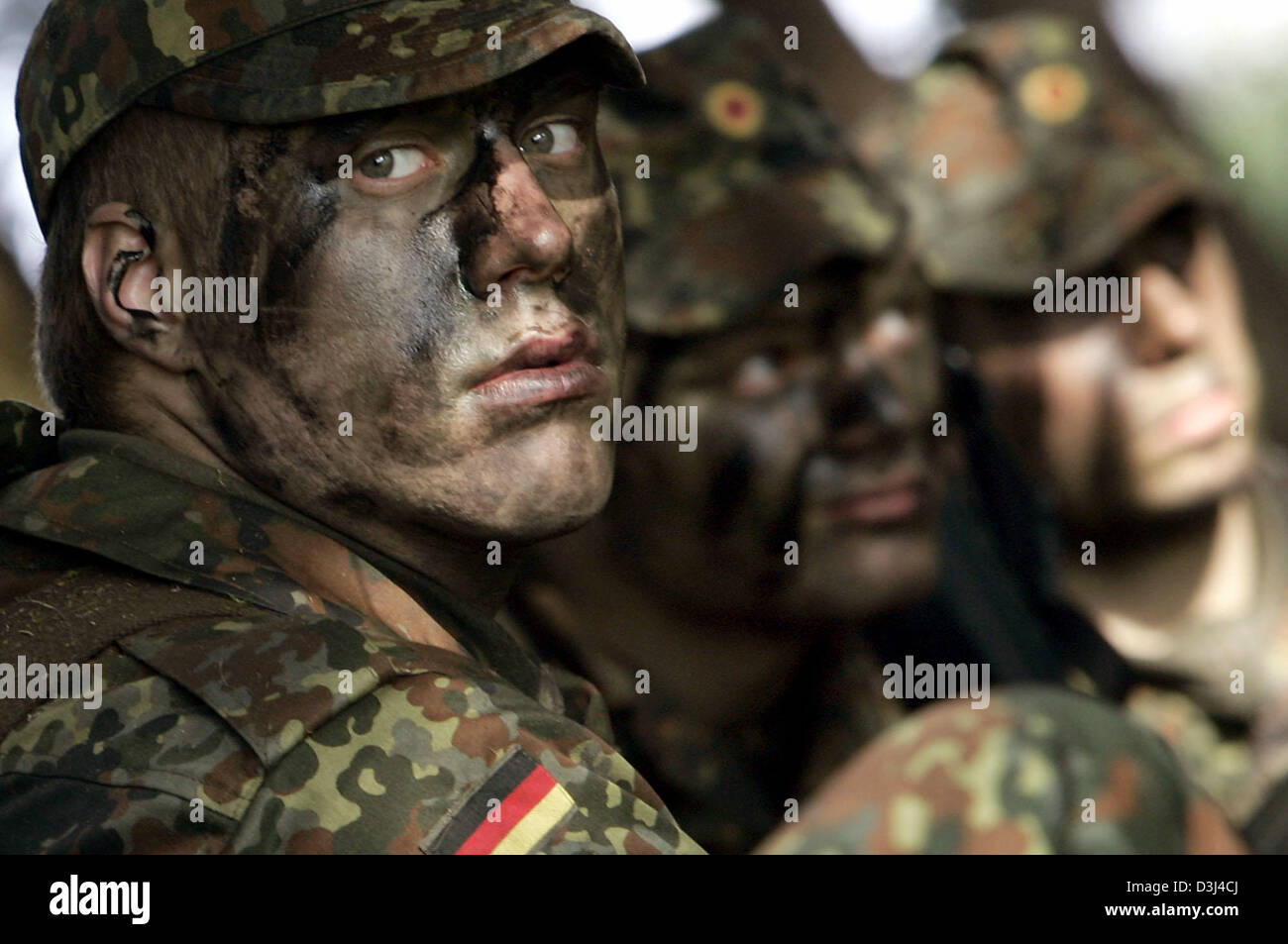 (Afp) - des soldats de l'infanterie blindée de la division de l'armée allemande, avec des visages peints et une tenue de camouflage, se mettre à couvert pendant un exercice sur le terrain dans le cadre de la formation militaire de base à la caserne en Knuell Schwarzenborn, Allemagne, 14 avril 2005. Banque D'Images