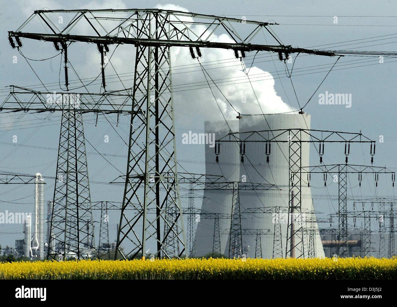 (Afp) - Une forêt de pylônes s'étend depuis les nuages de vapeur monte de la tour de refroidissement de la centrale électrique au charbon dans la région de Lippendorf, Allemagne, 4 mai 2004. Banque D'Images