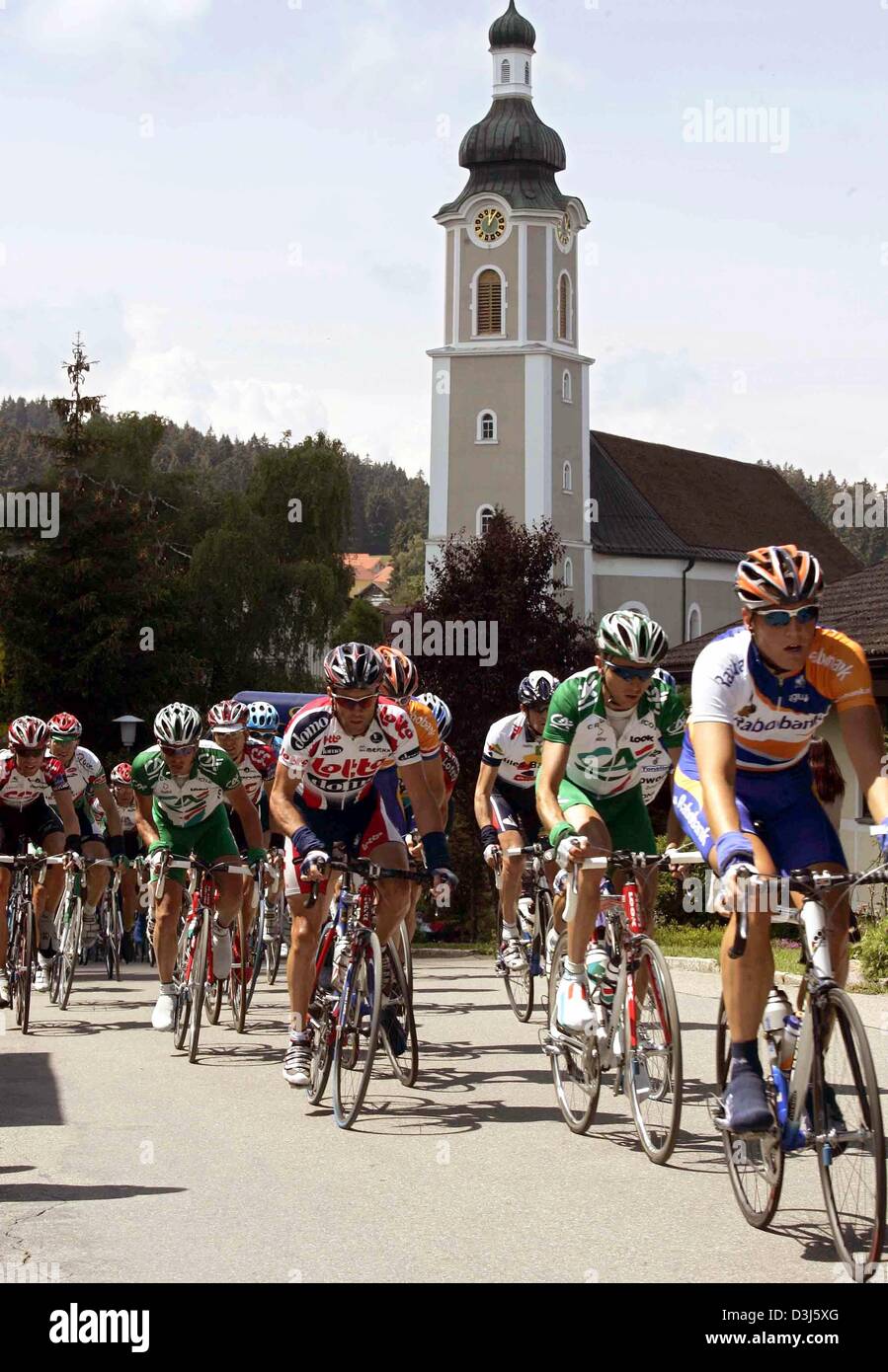 (Afp) - Les cyclistes roulent pendant 166,6 km de long troisième étape du Tour de France cycliste de Wangen im Allgaeu, Allemagne, à Sankt Anton, Autriche, passé une église dans la ville de Scheidegg, Allemagne, 2 juin 2004. Banque D'Images