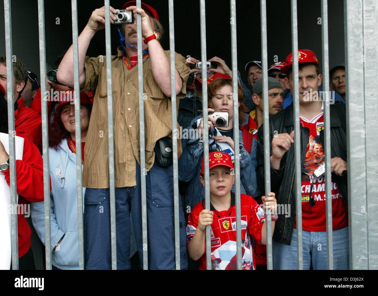 (Afp) - des fans de Formule 1 se tenir aux portes de l'enclos et essayez d'attraper un aperçu des pilotes à la piste de course de Nürburgring, en Allemagne, le 27 mai 2004. Le Grand Prix d'Europe va avoir lieu à la Nürburgring le 30 mai 2004. Banque D'Images